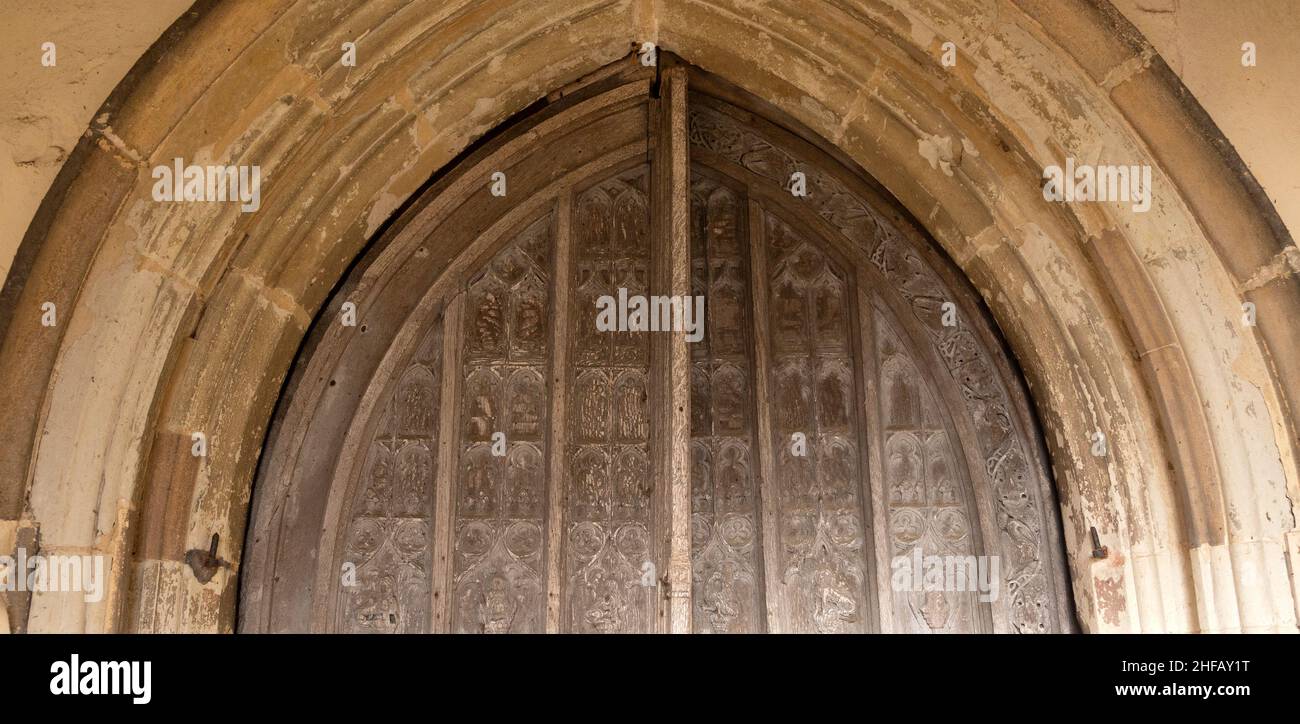 Detail of carved wooden door and stone surround, Assington church, Suffolk, England, UK Stock Photo