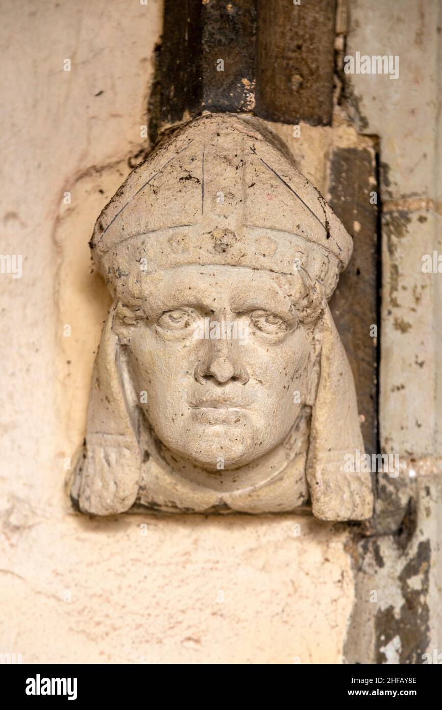 Stone carving male headstop in  doorway surround wearing bishop's mitre, Assington church, Suffolk, England, UK Stock Photo