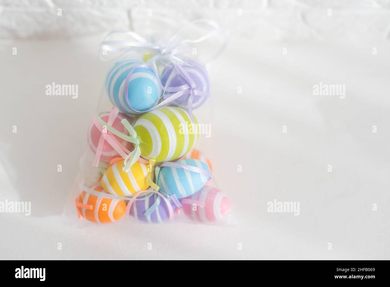 multi-colored chicken eggs in bag mesh on white background. easter Stock Photo