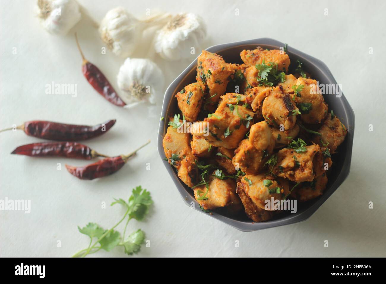 Chilli garlic chicken bites. A pan fried chicken dish with a strong garlic flavour and garnished with fresh coriander leaves. Marinated with garlic pa Stock Photo