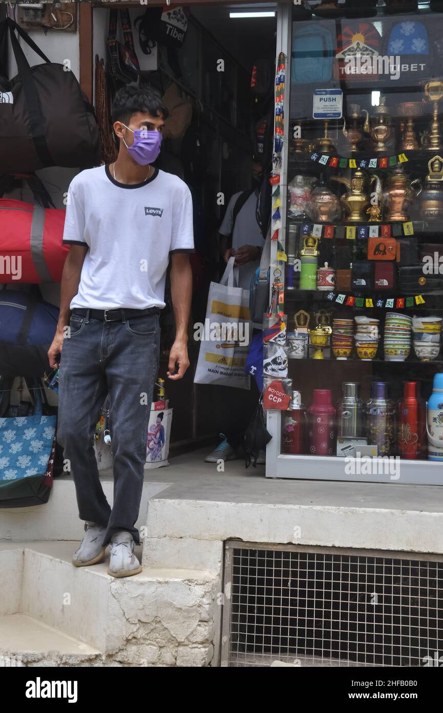 Mandi, Himachal Pradesh, India - 08 02 2021: People with wearing face mask coming out of tibetan souvenir shop during coronavirus pandemic Stock Photo