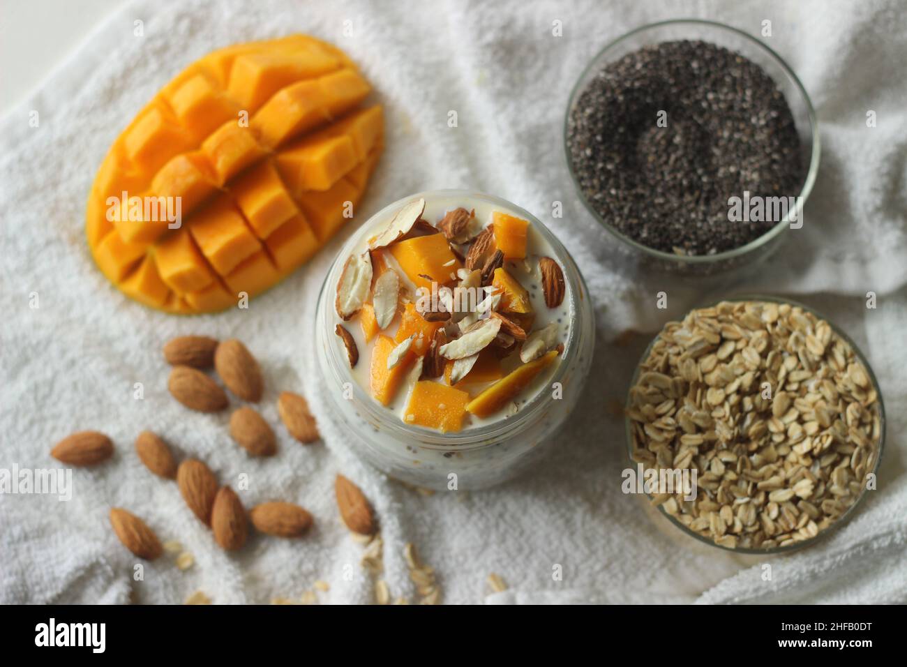 Overnight oats with mango and almonds. Made by soaking rolled oats and chia seeds in milk served