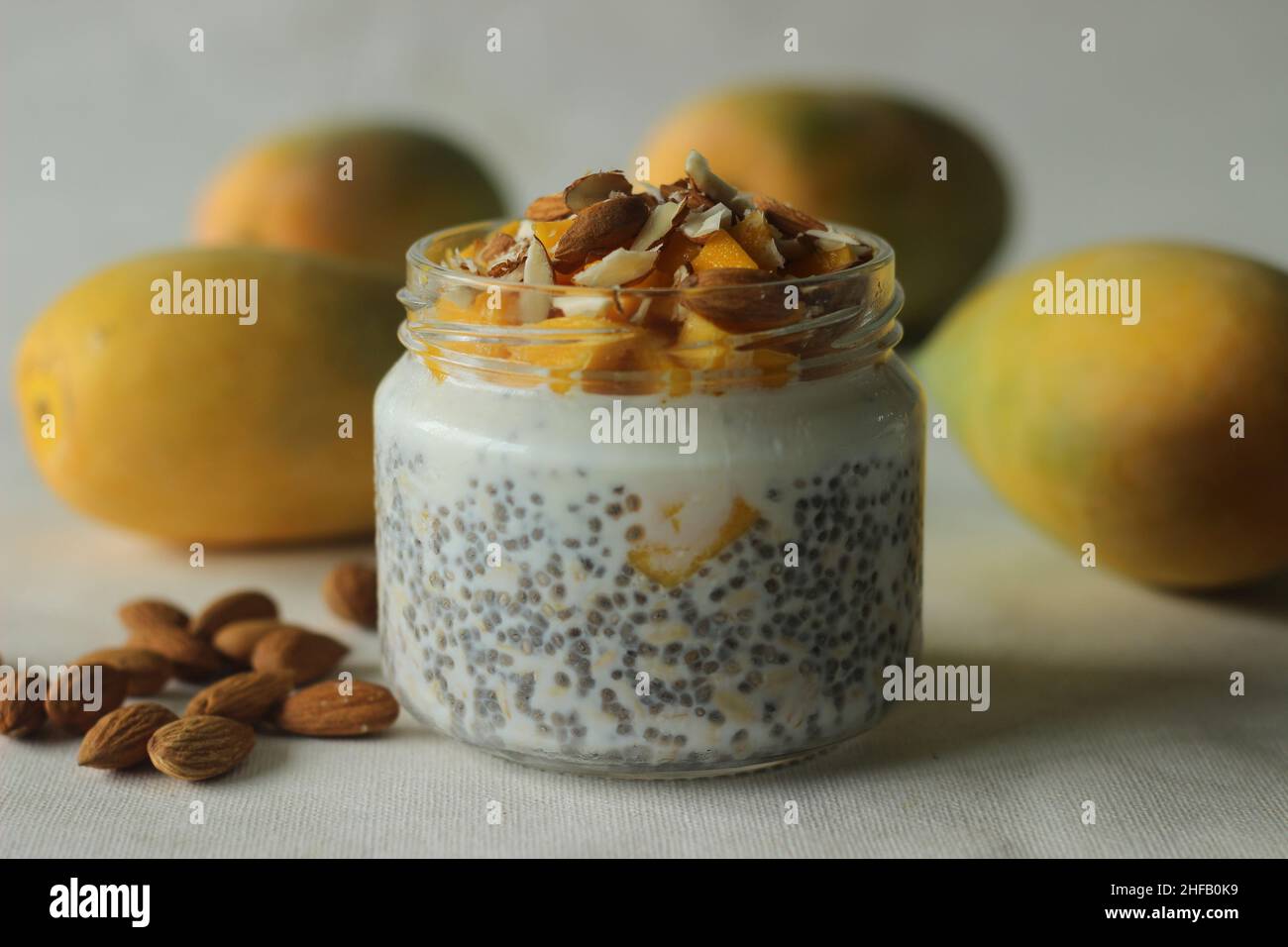 Overnight oats with mango and almonds. Made by soaking rolled oats and chia seeds in milk served