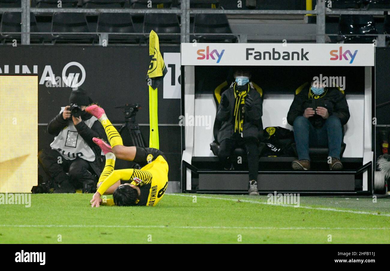 Signal Iduna Park Dortmund, Germany, 14.1.2022, Football: Bundesliga Season 2021/22, matchday 19, Borussia Dortmund (BVB) vs SC Freiburg (SCF) - Mahmoud Dahoud (BVB) rolls over in celebration in front of the BVB team photographer and two fans on a sponsor’s fan bank  DFL REGULATIONS PROHIBIT ANY USE OF PHOTOGRAPHS AS IMAGE SEQUENCES AND/OR QUASI-VIDEO Stock Photo