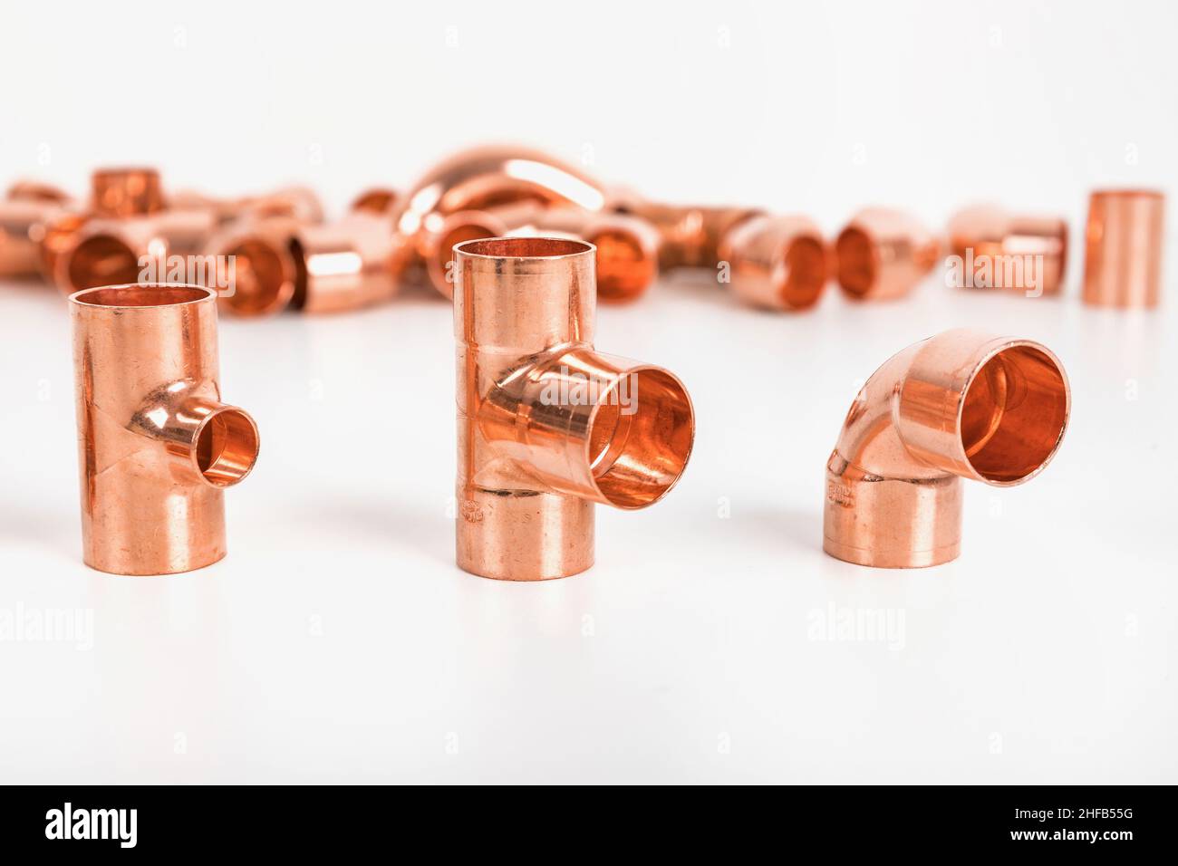 Group of fittings on a white background. Copper fittings for pipe connections. Technical basis for heating companies. Stock Photo