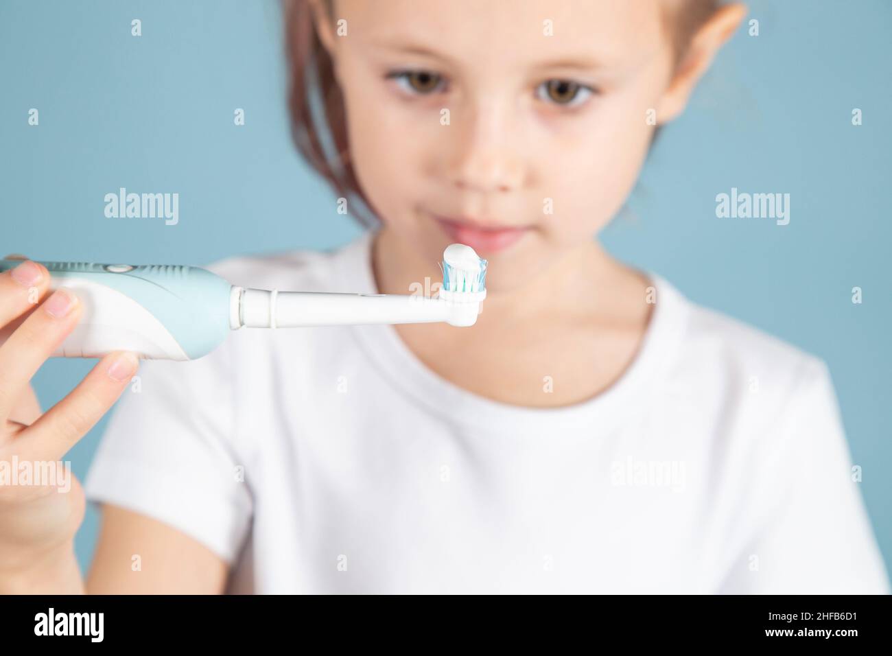 Adorable little caucasian child holding tooth brushStanding Over blue Background, hygiene concept Stock Photo