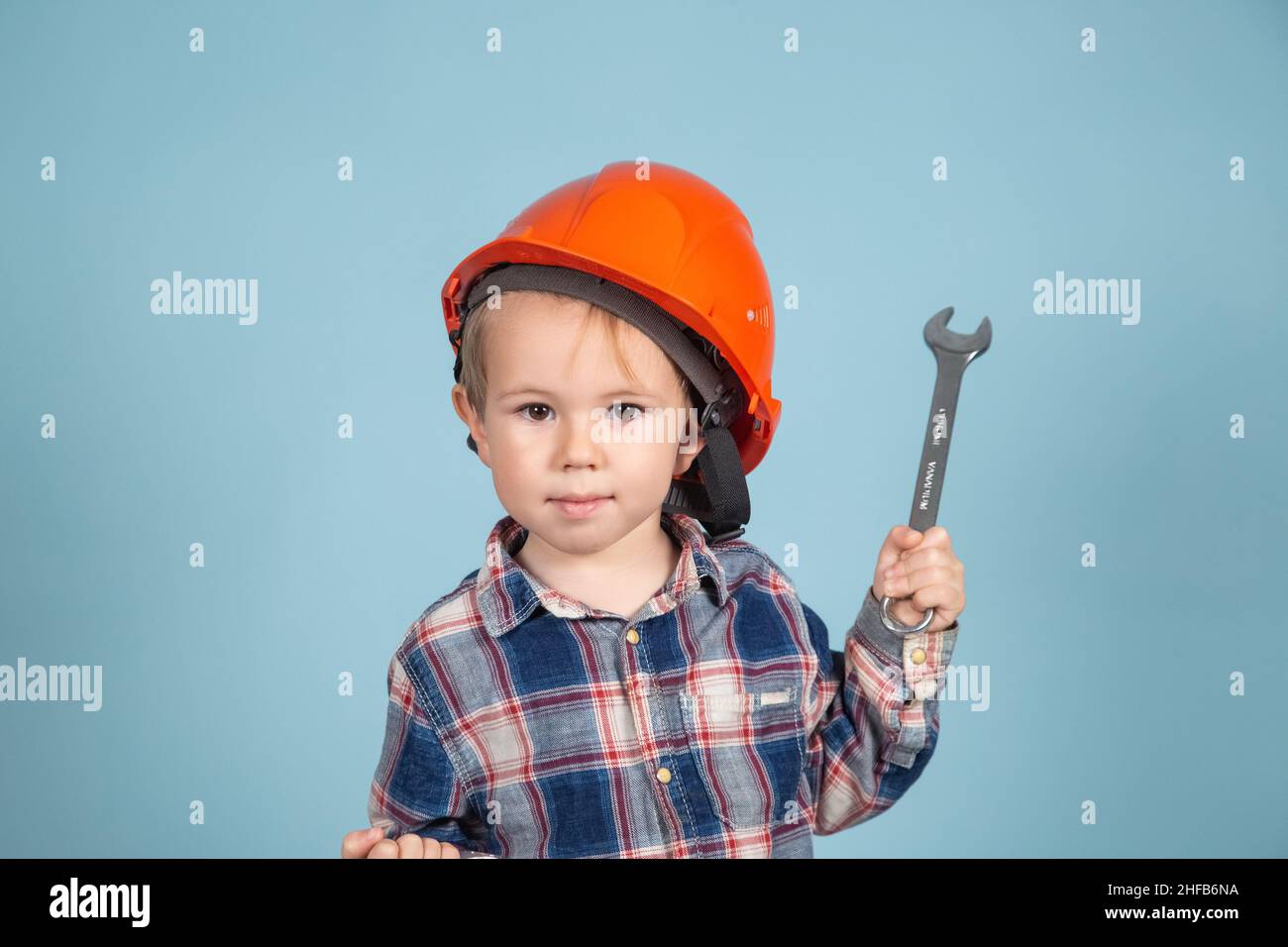 Child is holding wrenches. Construction and repair concept. A little boy is holding an adjustable tool in her hands. Stock Photo