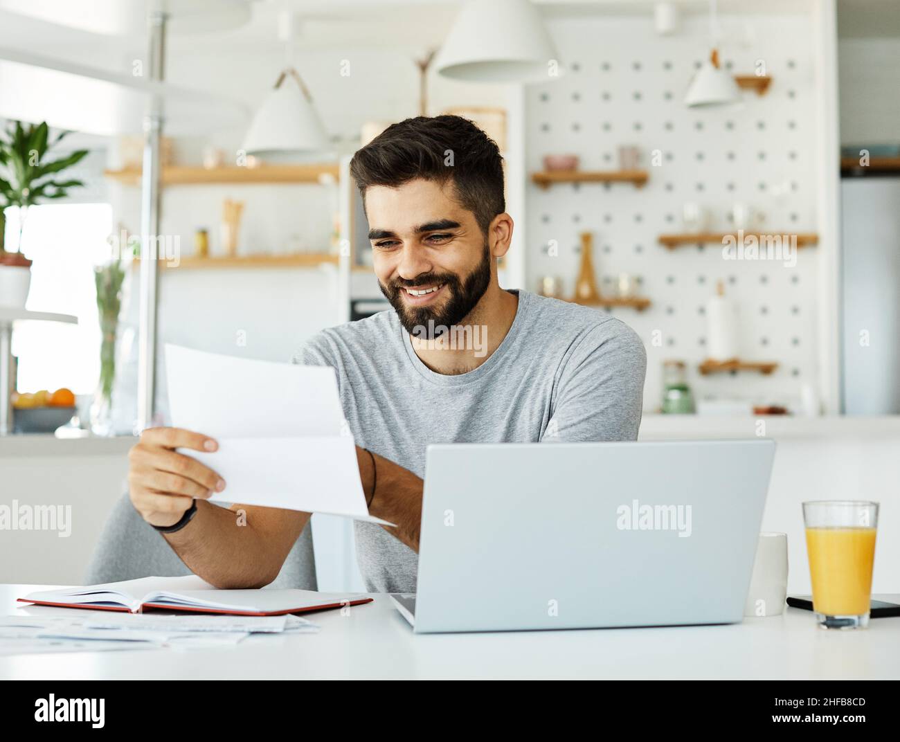 laptop man computer home technology young student business internet study document paperwork reading Stock Photo