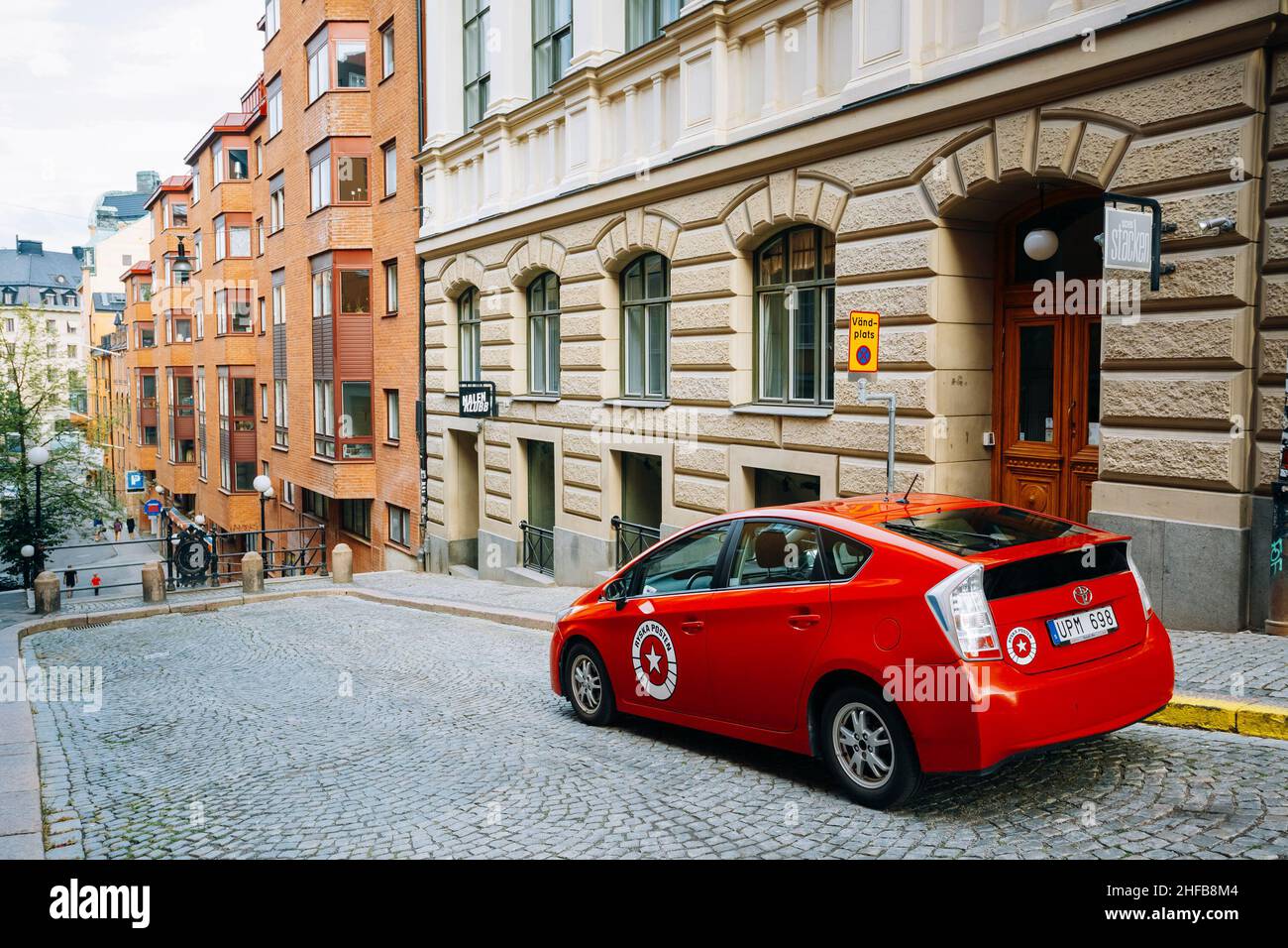 Red color Toyota Prius car parked at sidewalk on the David Bagares street Stockholm, Sweden Stock Photo
