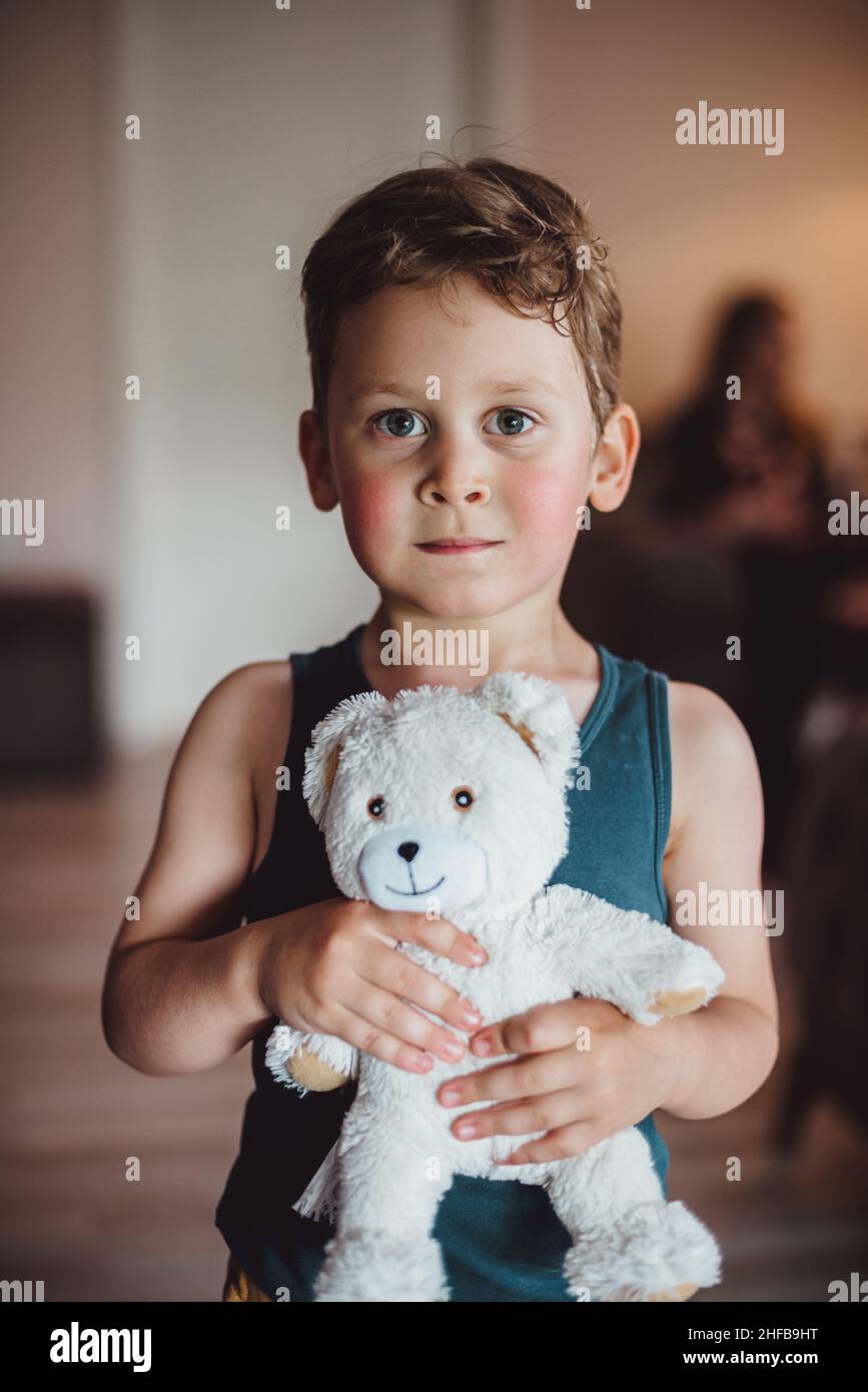 young child boy holding his teddy bear, looking at camera Stock Photo