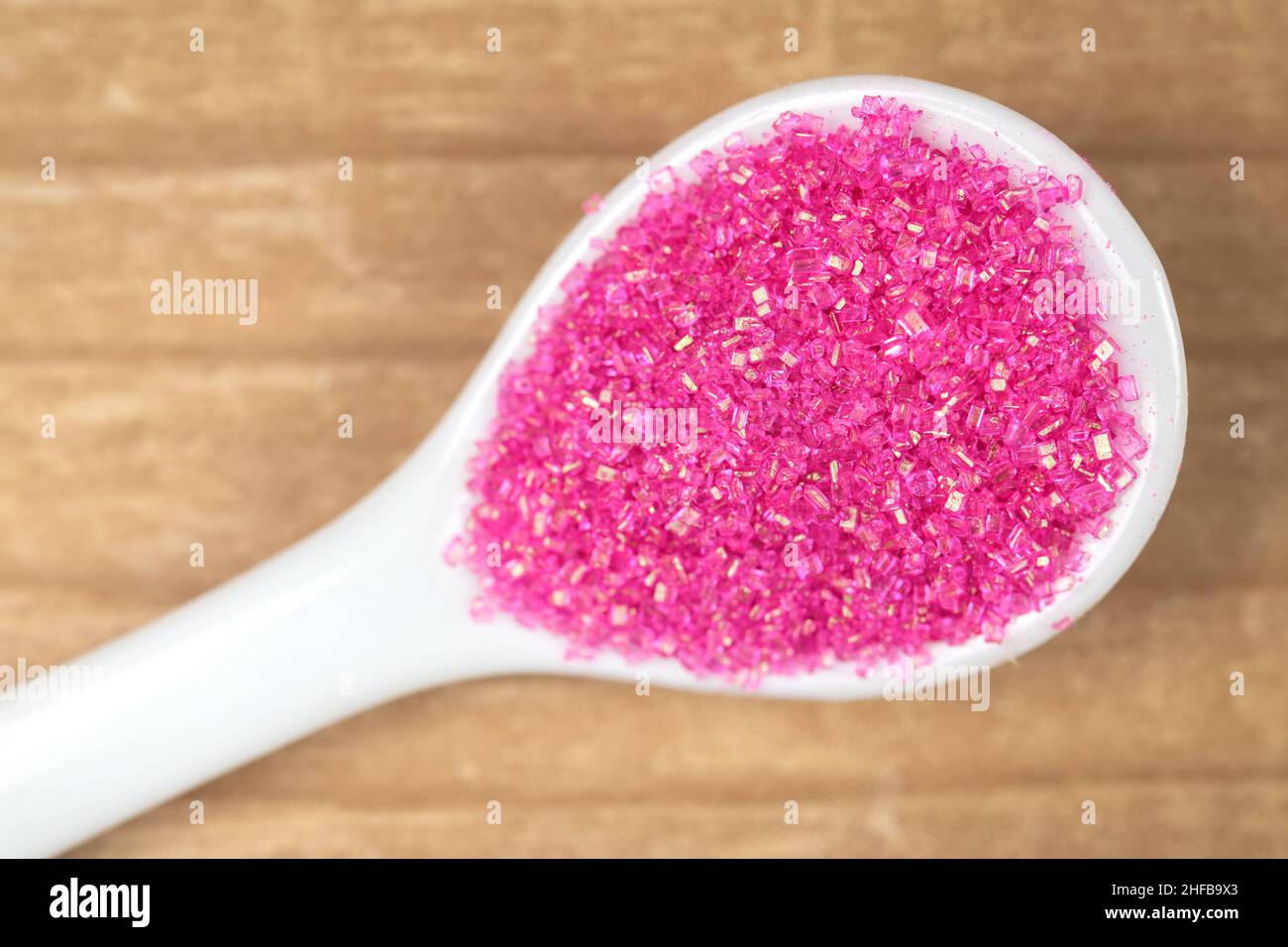 Confectionary pink sugar in a white spoon Stock Photo