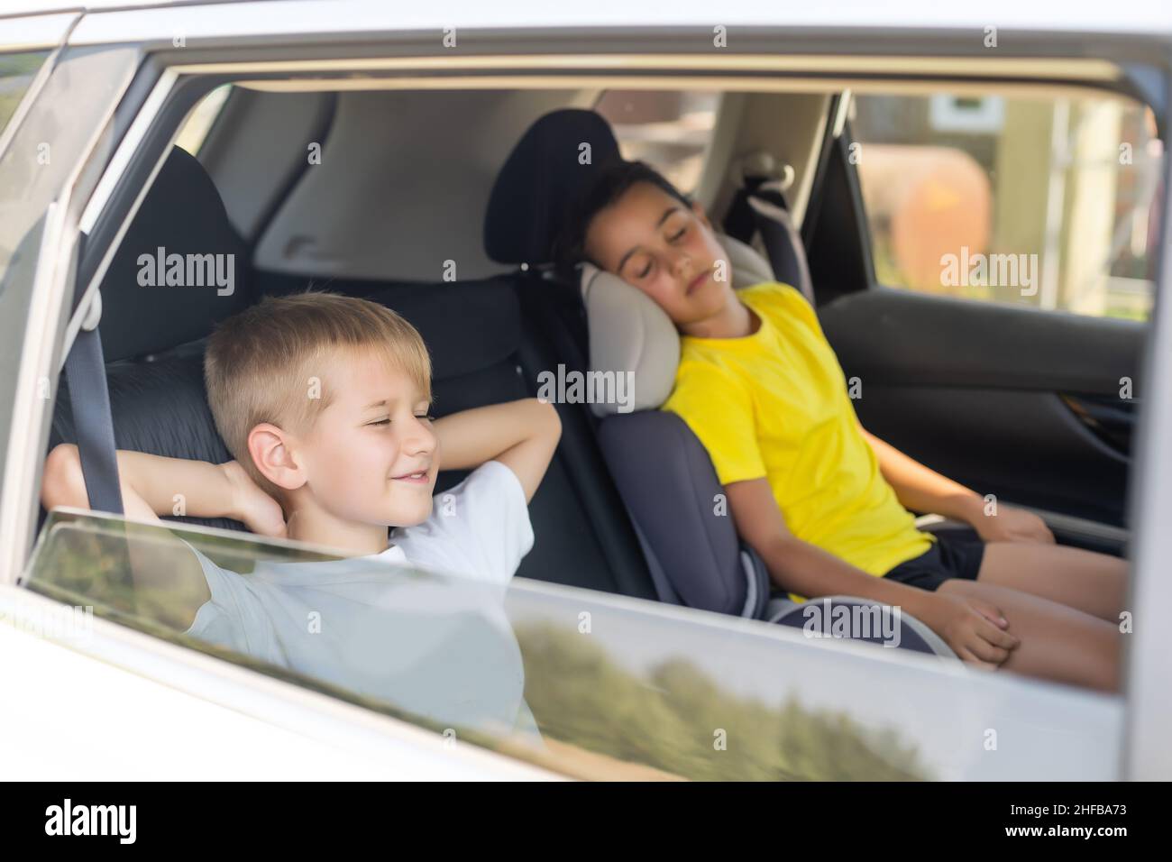 Smiling kids sitting on back seat of car Stock Photo - Alamy