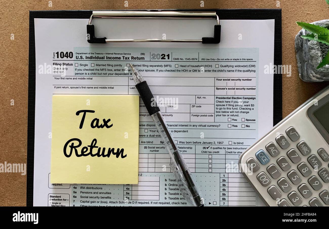 Tax return on sticky note for on US individual 1040 tax form, pen and ...