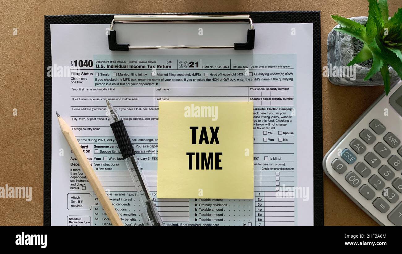 Tax time on sticky note for US individual, 1040 tax form, pen and pencil. Tax concept. Stock Photo