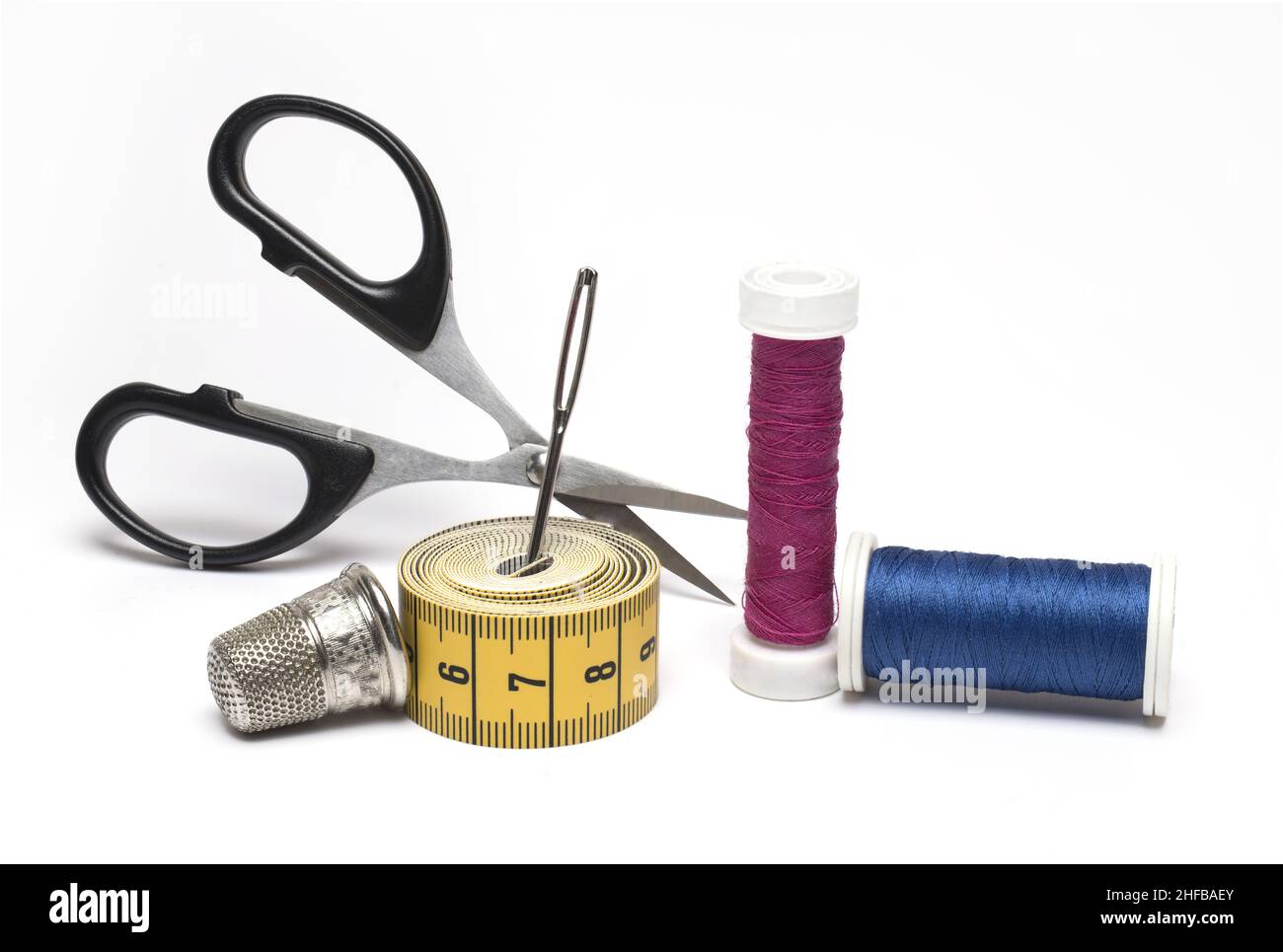 Close up of sewing kit scissors sewing needle different rolls of sewing