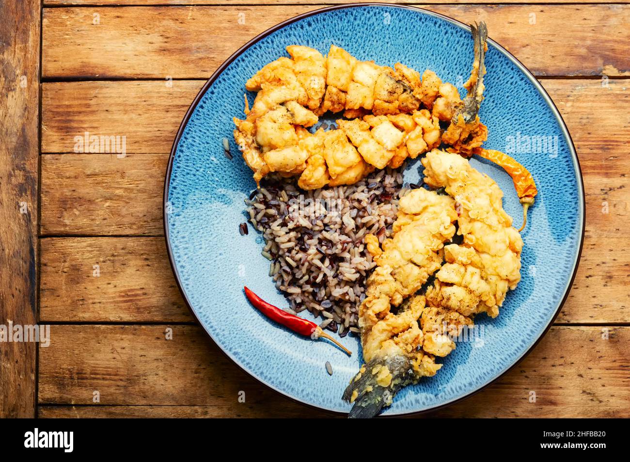 Fried sea bass fish with rice on rice paper. Roasted seafood Stock Photo Alamy