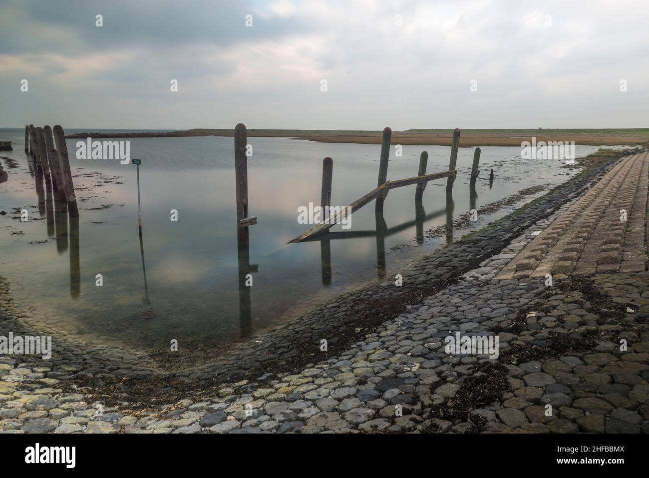Wooden poles as remainder of a historic harbor in an inlayer (inlaag) of Noord-Beveland, Zeeland province, Netherlands Stock Photo
