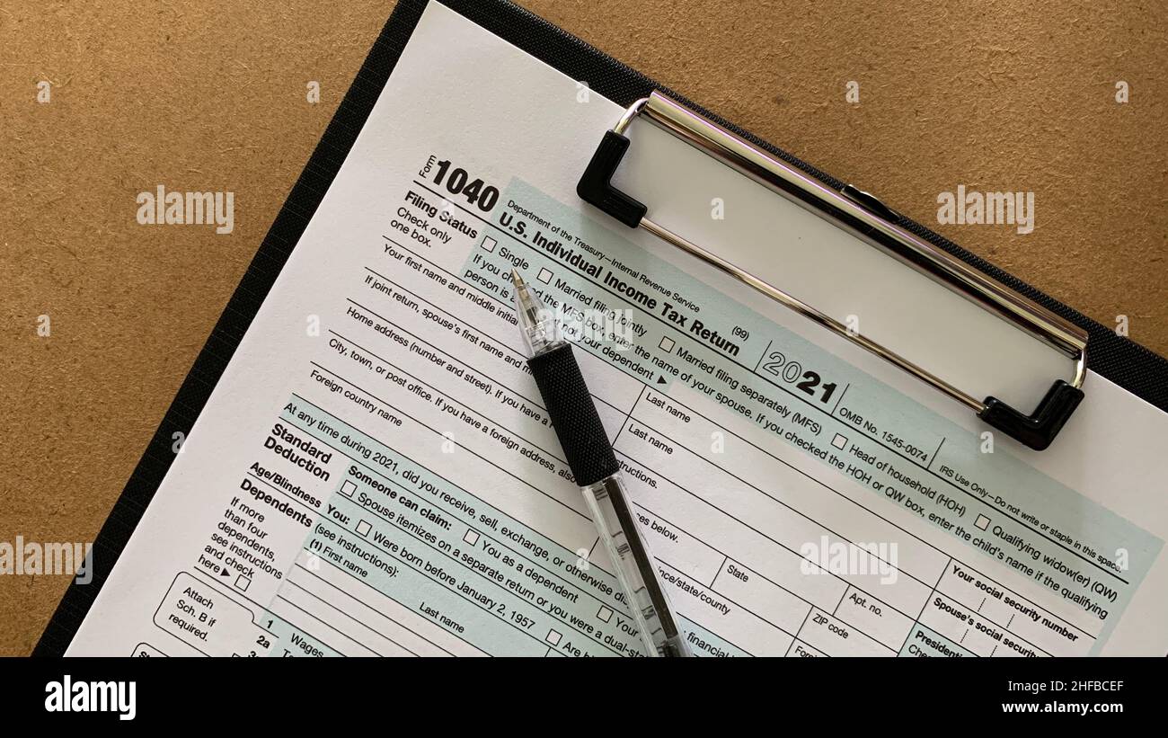 1040 tax form with pen and brown table background. Tax concept Stock Photo