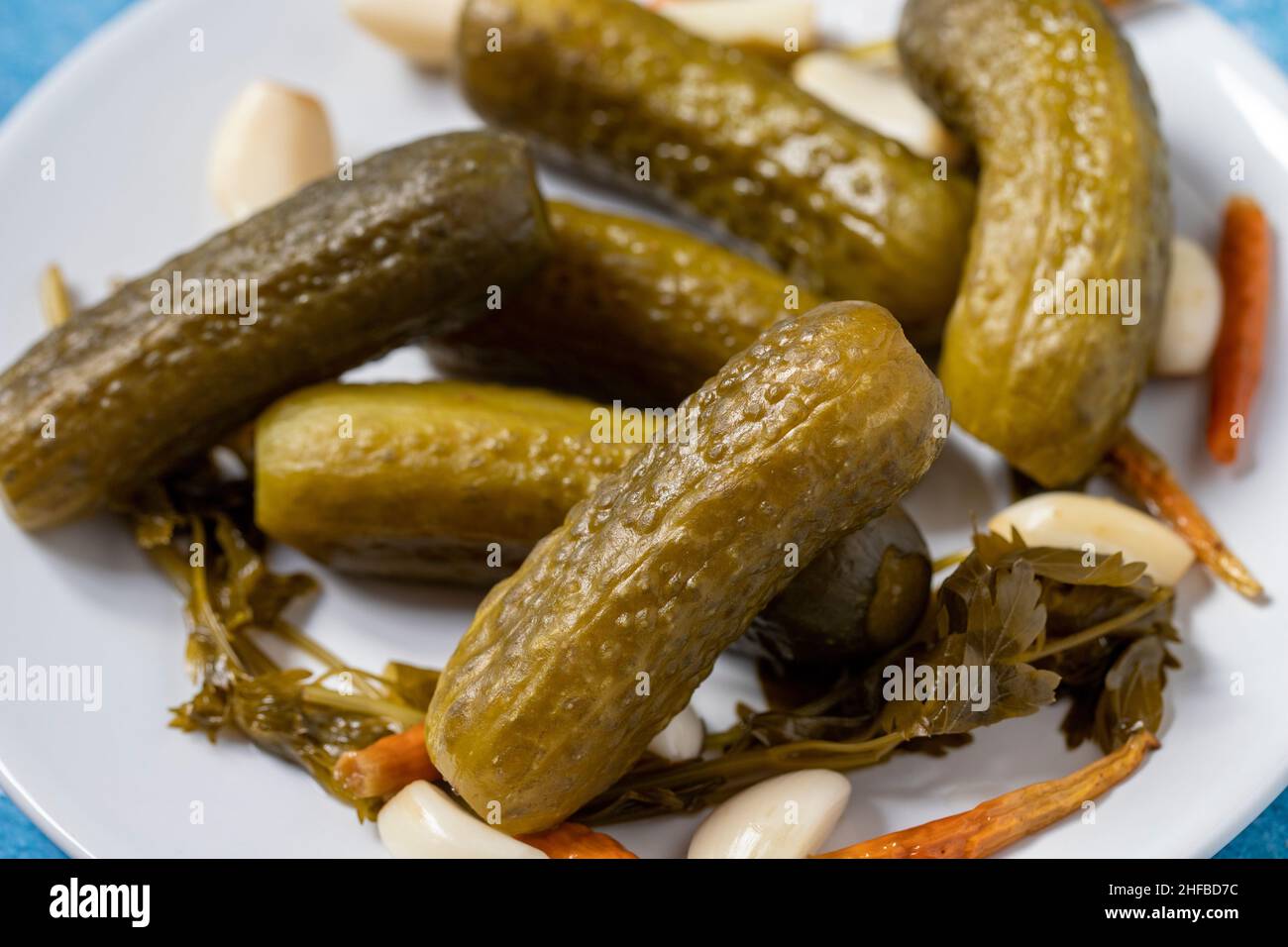Pickled cucumbers on rusty iron background. Close-up of pickled cucumbers in a ceramic plate. close up Stock Photo