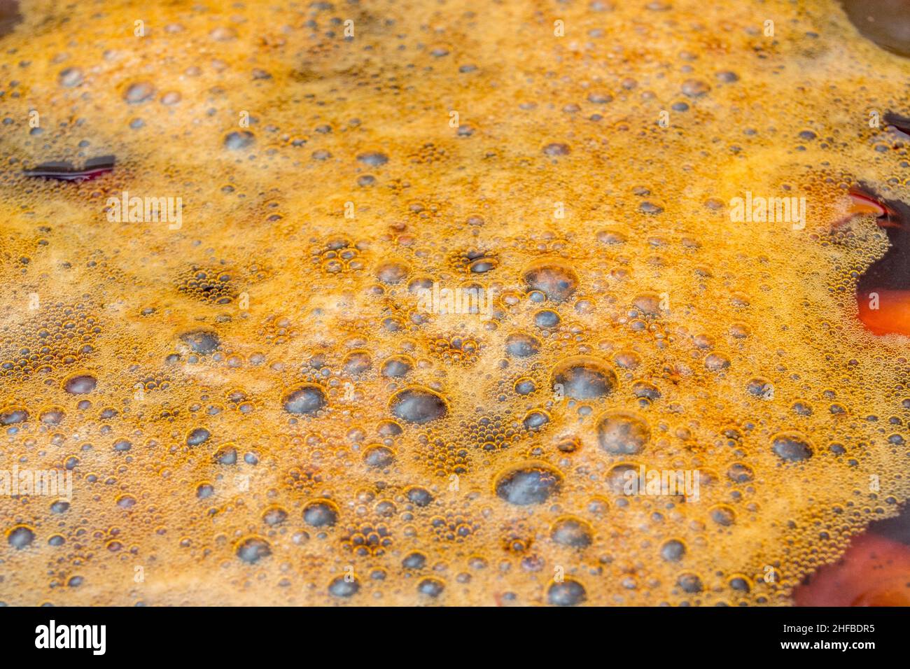 Gas bubbles from Hydrogen Peroxide / H2O2 in presence of mild acid working on rusty steel. For chemical reaction, decomposition, school chemistry. Stock Photo