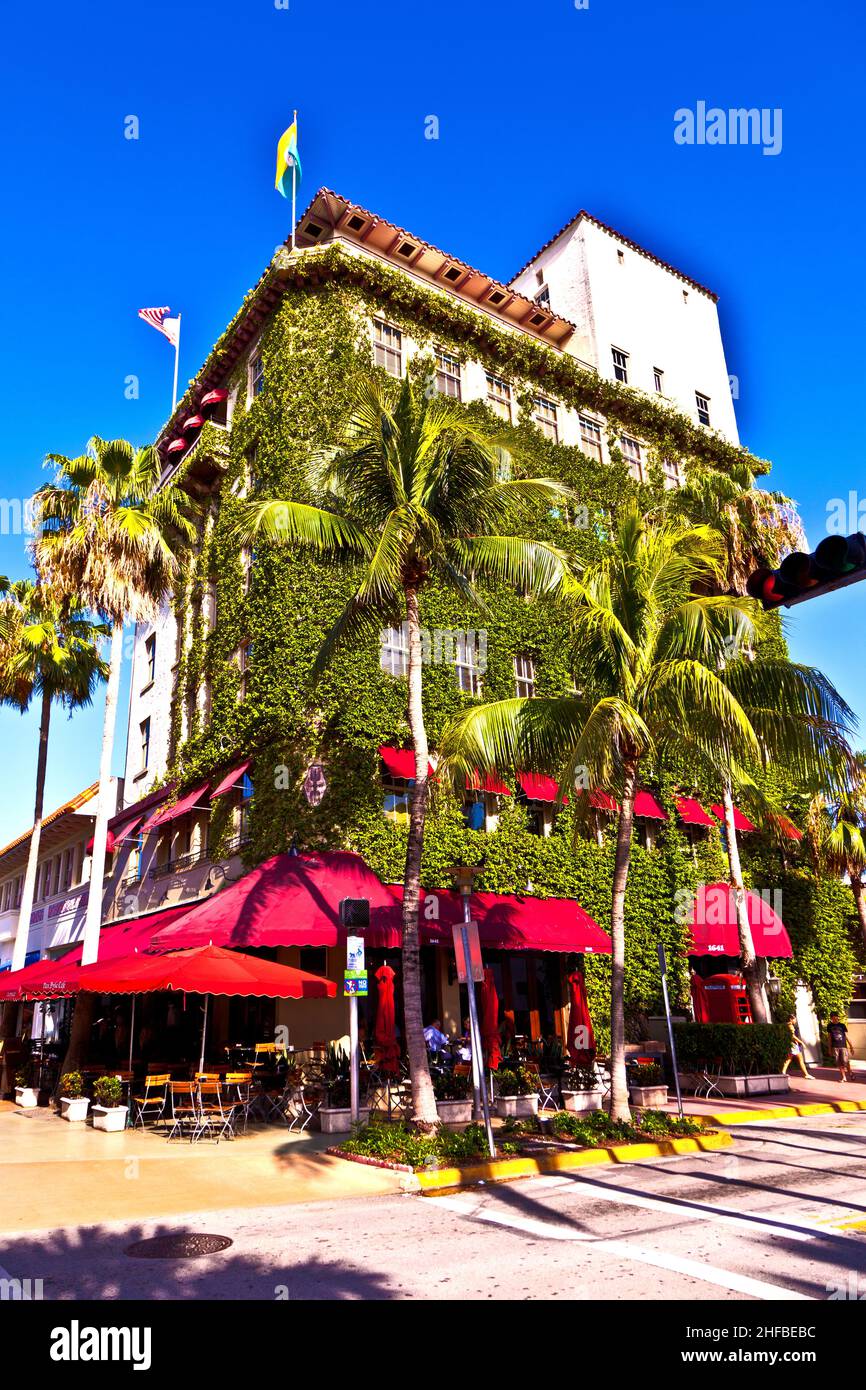 old typical building in art deco style in South Miami with climbing plants and a cafe Stock Photo