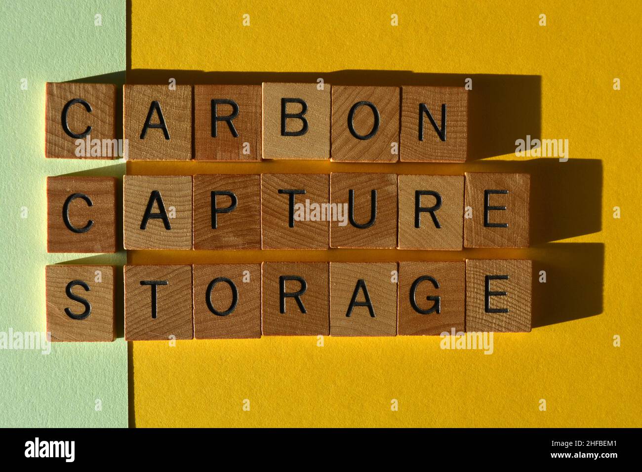 CCS acronym for Carbon Capture Storage, words in wooden alphabet letters isolated on green and yellow background Stock Photo
