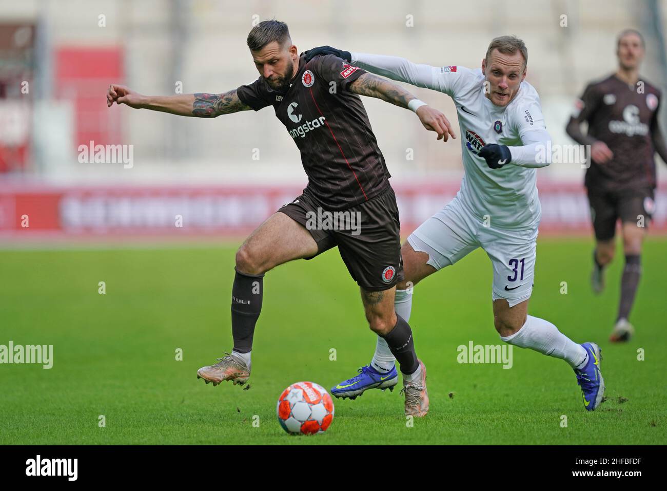 Hamburg, Germany. 15th Jan, 2022. Soccer: 2nd Bundesliga, Matchday 19, FC St. Pauli - Erzgebirge Aue, at Millerntor Stadium. St. Pauli's Guido Burgstaller (l) and Aue's Ben Zolinski. Credit: Marcus Brandt/dpa - IMPORTANT NOTE: In accordance with the requirements of the DFL Deutsche Fußball Liga and the DFB Deutscher Fußball-Bund, it is prohibited to use or have used photographs taken in the stadium and/or of the match in the form of sequence pictures and/or video-like photo series./dpa/Alamy Live News Stock Photo