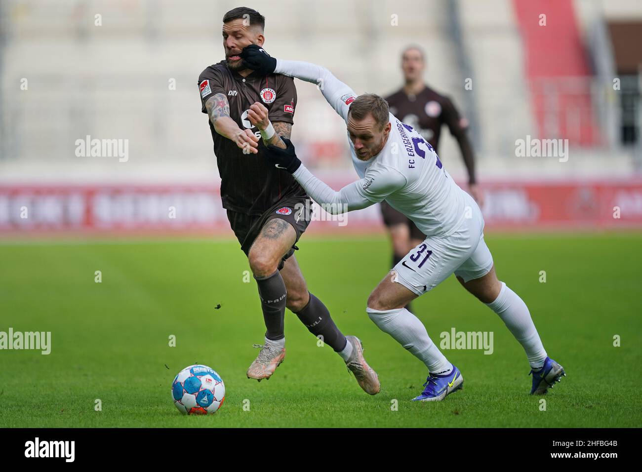 Hamburg, Germany. 15th Jan, 2022. Soccer: 2nd Bundesliga, Matchday 19, FC St. Pauli - Erzgebirge Aue, at Millerntor Stadium. St. Pauli's Guido Burgstaller (l) and Aue's Ben Zolinski. Credit: Marcus Brandt/dpa - IMPORTANT NOTE: In accordance with the requirements of the DFL Deutsche Fußball Liga and the DFB Deutscher Fußball-Bund, it is prohibited to use or have used photographs taken in the stadium and/or of the match in the form of sequence pictures and/or video-like photo series./dpa/Alamy Live News Stock Photo