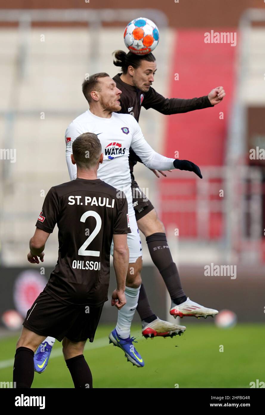 Hamburg, Germany. 15th Jan, 2022. Soccer: 2. Bundesliga, 19th matchday, FC St. Pauli - Erzgebirge Aue, at Millerntor Stadium. St. Pauli's Jackson Irvine (r-l), Aue's Ben Zolinski and St. Pauli's Sebastian Ohlsson. Credit: Marcus Brandt/dpa - IMPORTANT NOTE: In accordance with the requirements of the DFL Deutsche Fußball Liga and the DFB Deutscher Fußball-Bund, it is prohibited to use or have used photographs taken in the stadium and/or of the match in the form of sequence pictures and/or video-like photo series./dpa/Alamy Live News Stock Photo