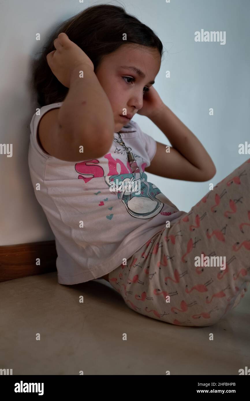 Bored little girl in isolation at home during quarantine COVID 19 Outbreak. Mental health Impact of coronavirus lockdown and social distancing. Stock Photo