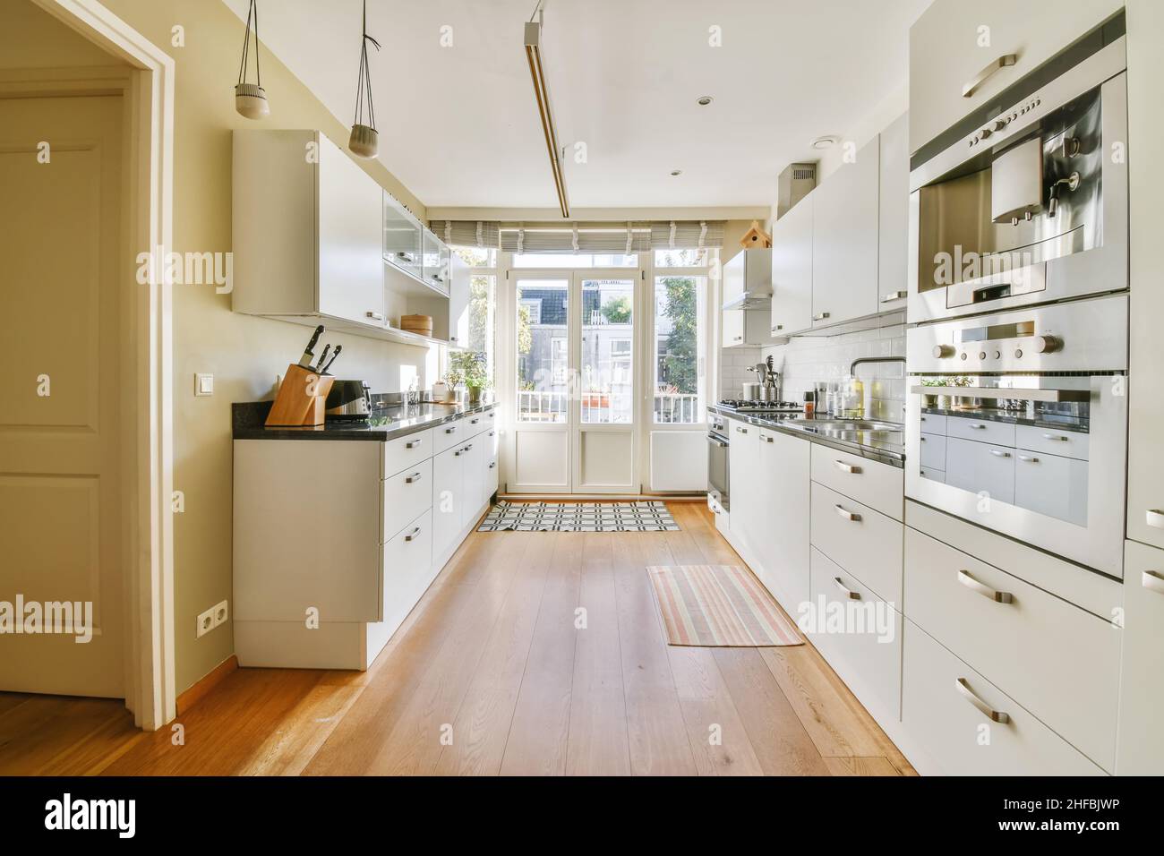 Luxurious kitchen area with parquet flooring and a crisp white kitchen ...