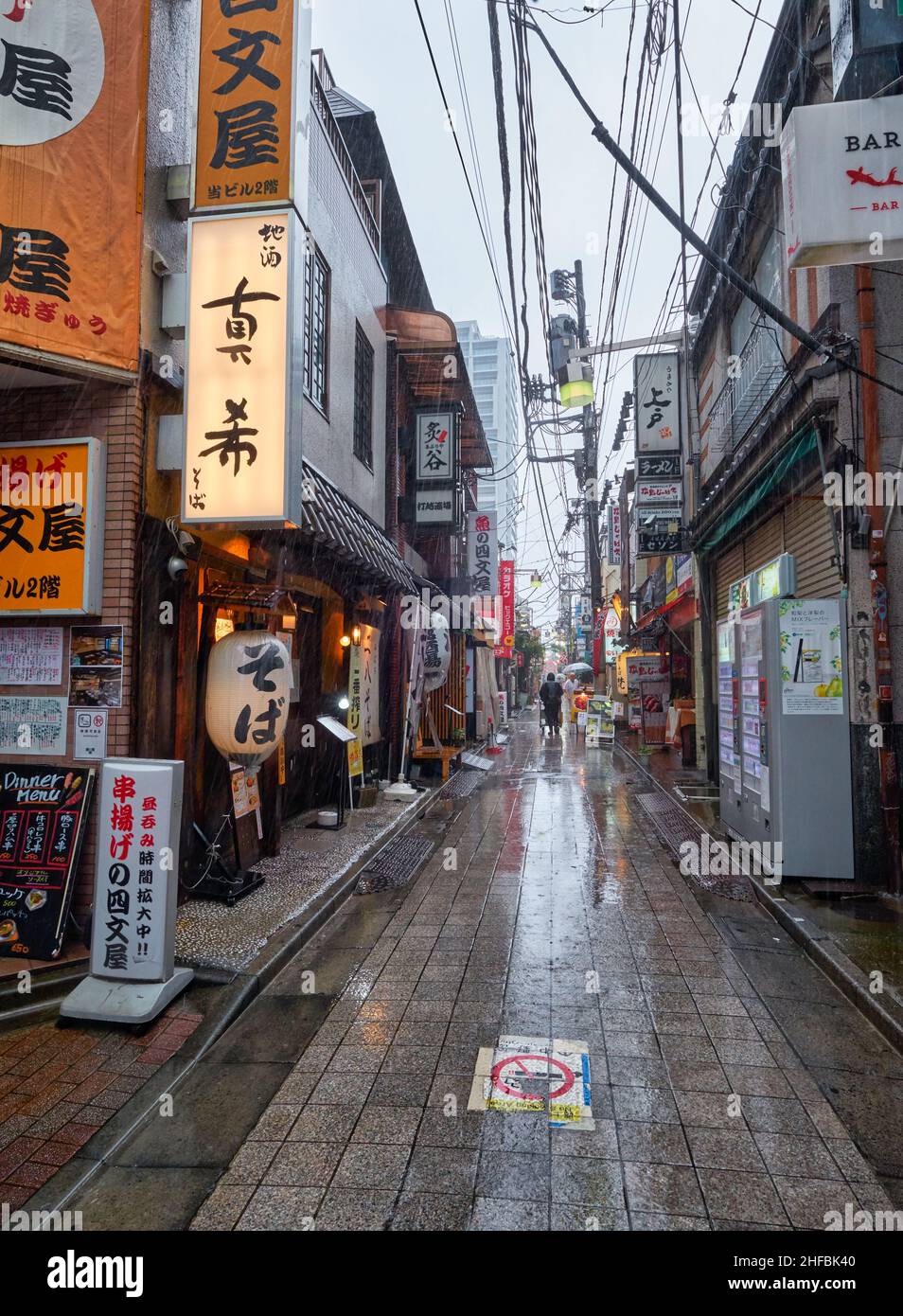 Tokyo, Japan - October 25, 2019: The view of the old market street with bars and restaurants under the heavy rain at twilight. Shibuya city. Tokyo. Ja Stock Photo