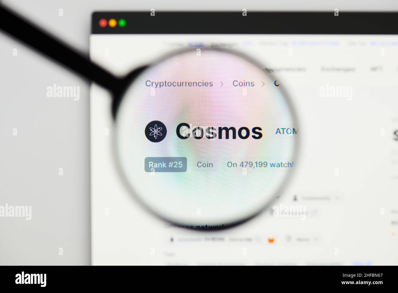 Milan, Italy - January 11, 2022: cosmos - ATOM website's hp.  cosmos, ATOM coin logo visible through a loope. Defi, ntf, cryptocurrency concepts illus Stock Photo