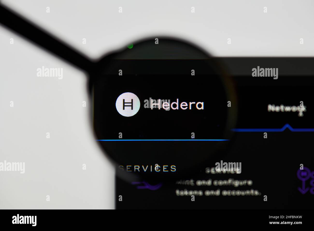 Milan, Italy - January 11, 2022: hedera - HBAR website's hp.  hedera, HBAR coin logo visible through a loope. Defi, ntf, cryptocurrency concepts illus Stock Photo