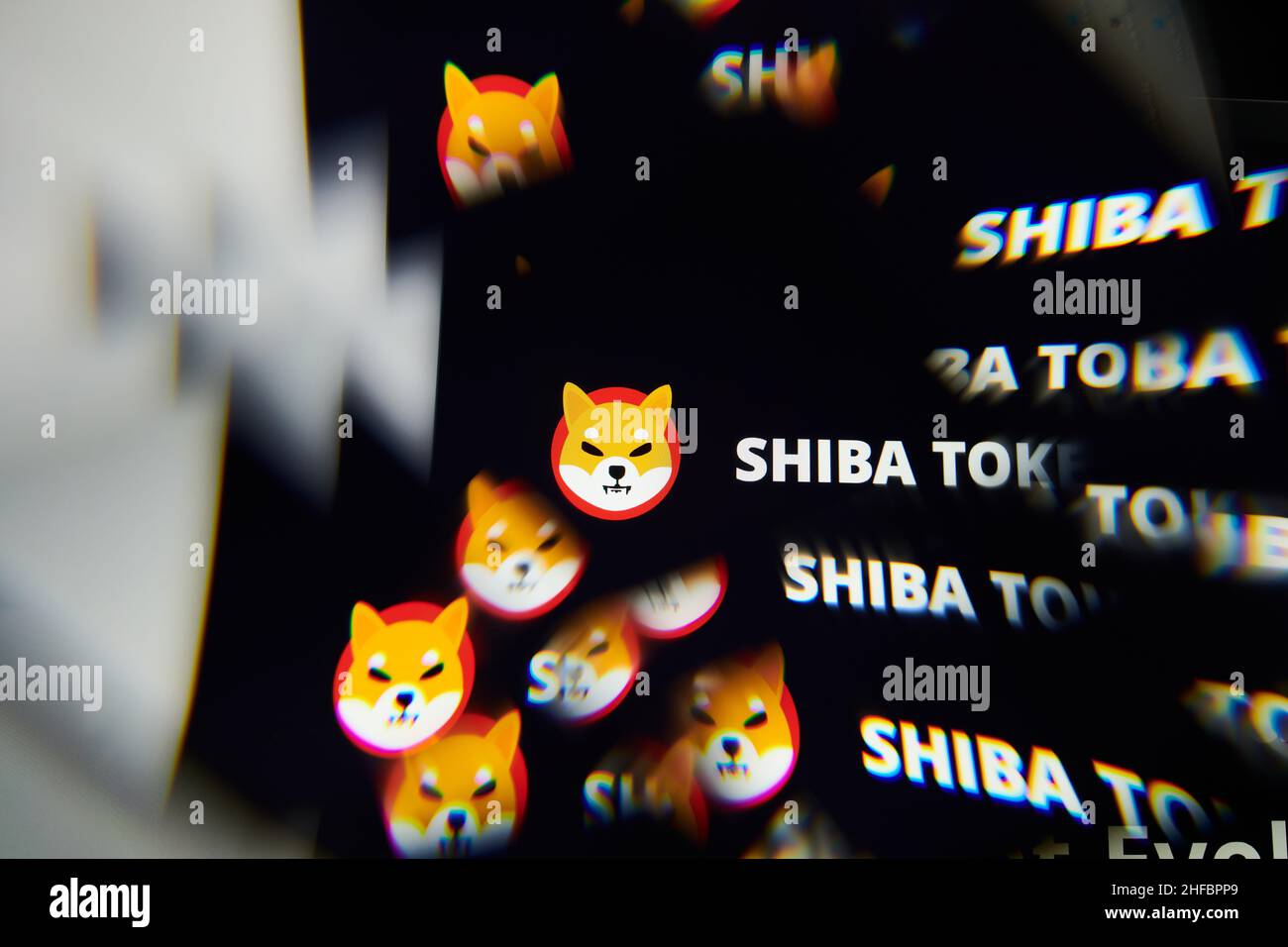 Milan, Italy - January 11, 2022: shiba inu - SHIB logo on laptop screen seen through an optical prism. Dynamic and unique image form shiba inu, SHIB c Stock Photo