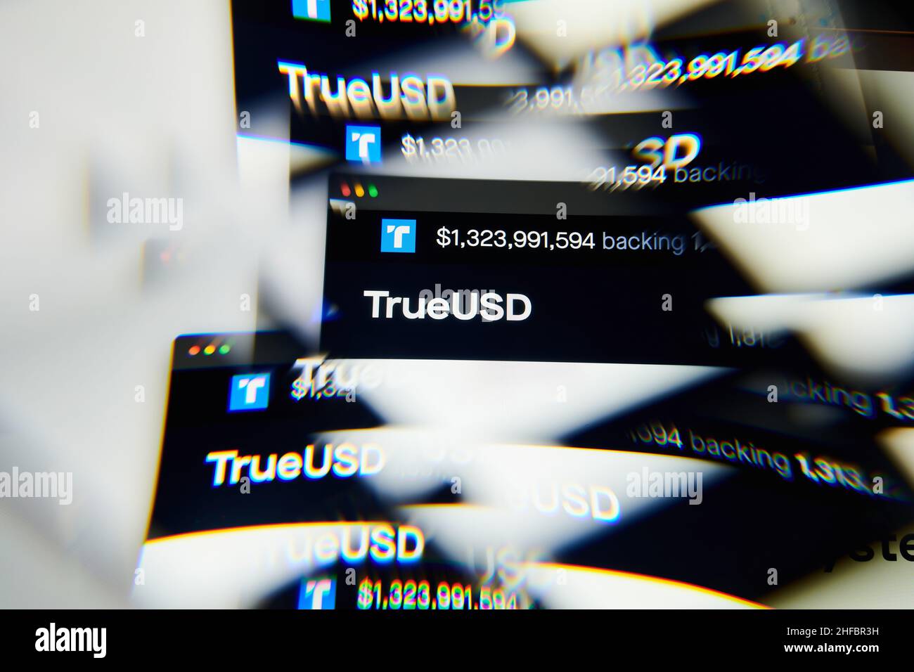 Milan, Italy - January 11, 2022: trueusd - TUSD logo on laptop screen seen through an optical prism. Dynamic and unique image form trueusd, TUSD coin Stock Photo