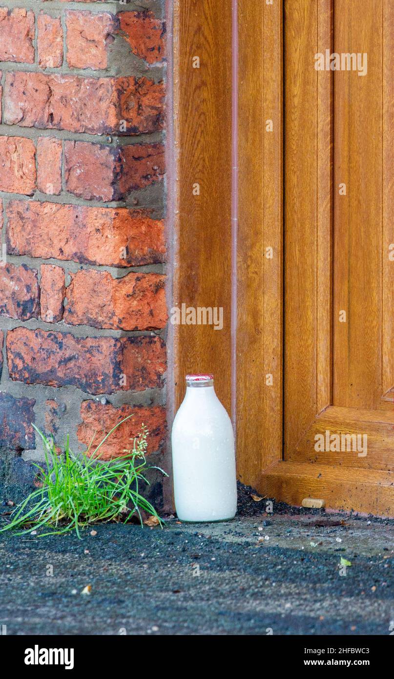 Single full pint milk bottle on a doorstep after being delivered by a