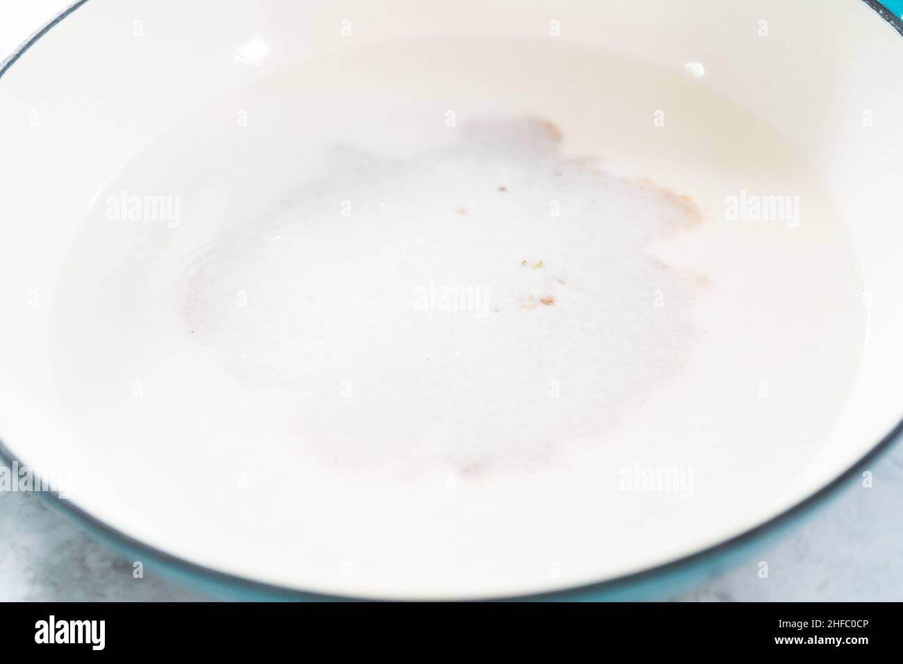 Cleaning cast iron enameled braiser with baking soda and vinegar Stock