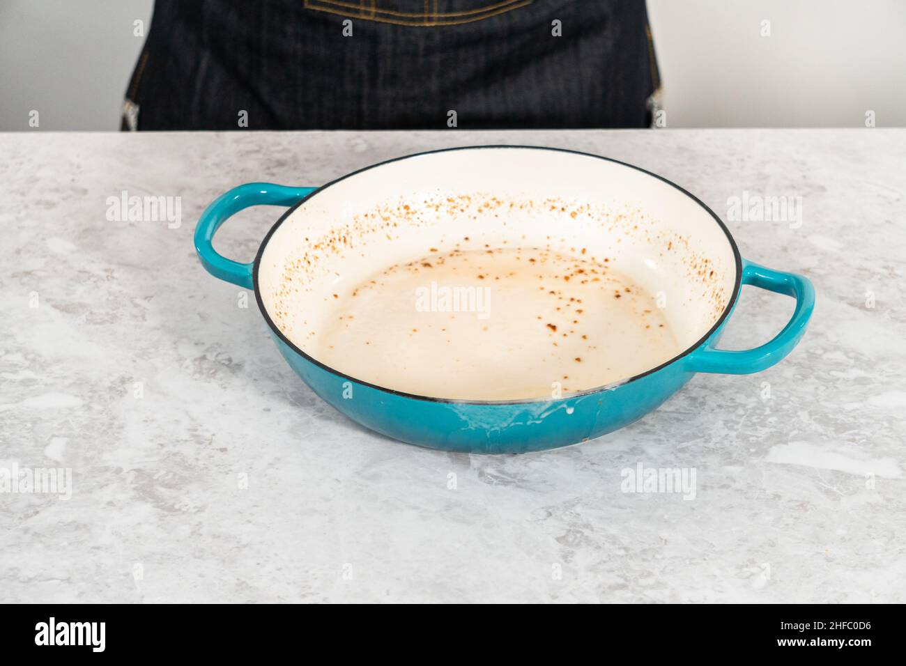 Cleaning cast iron enameled braiser with baking soda and vinegar Stock