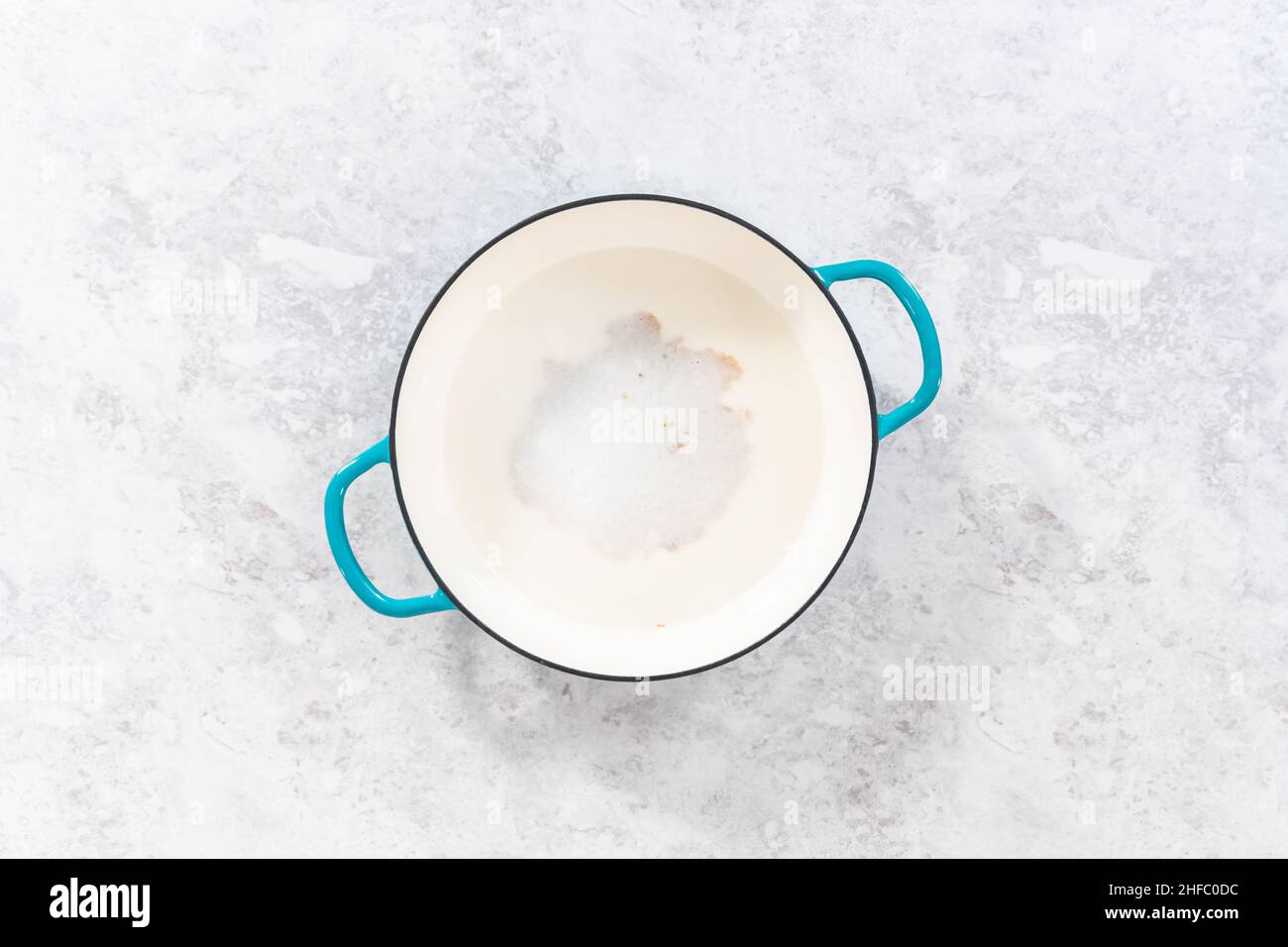 Cleaning cast iron enameled braiser with baking soda and vinegar Stock