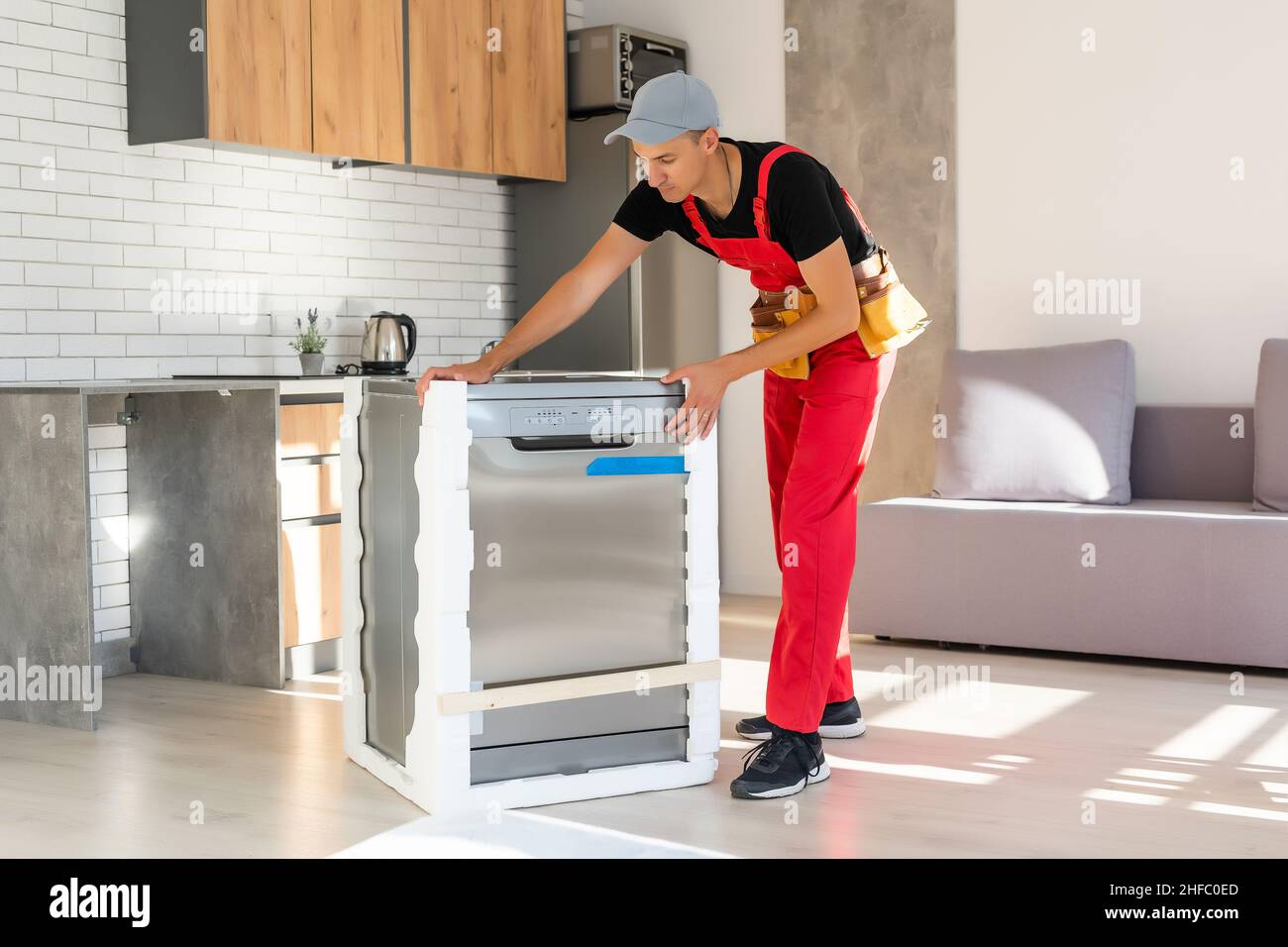 Young Repairman Service Worker Repairing Dishwasher Appliance In