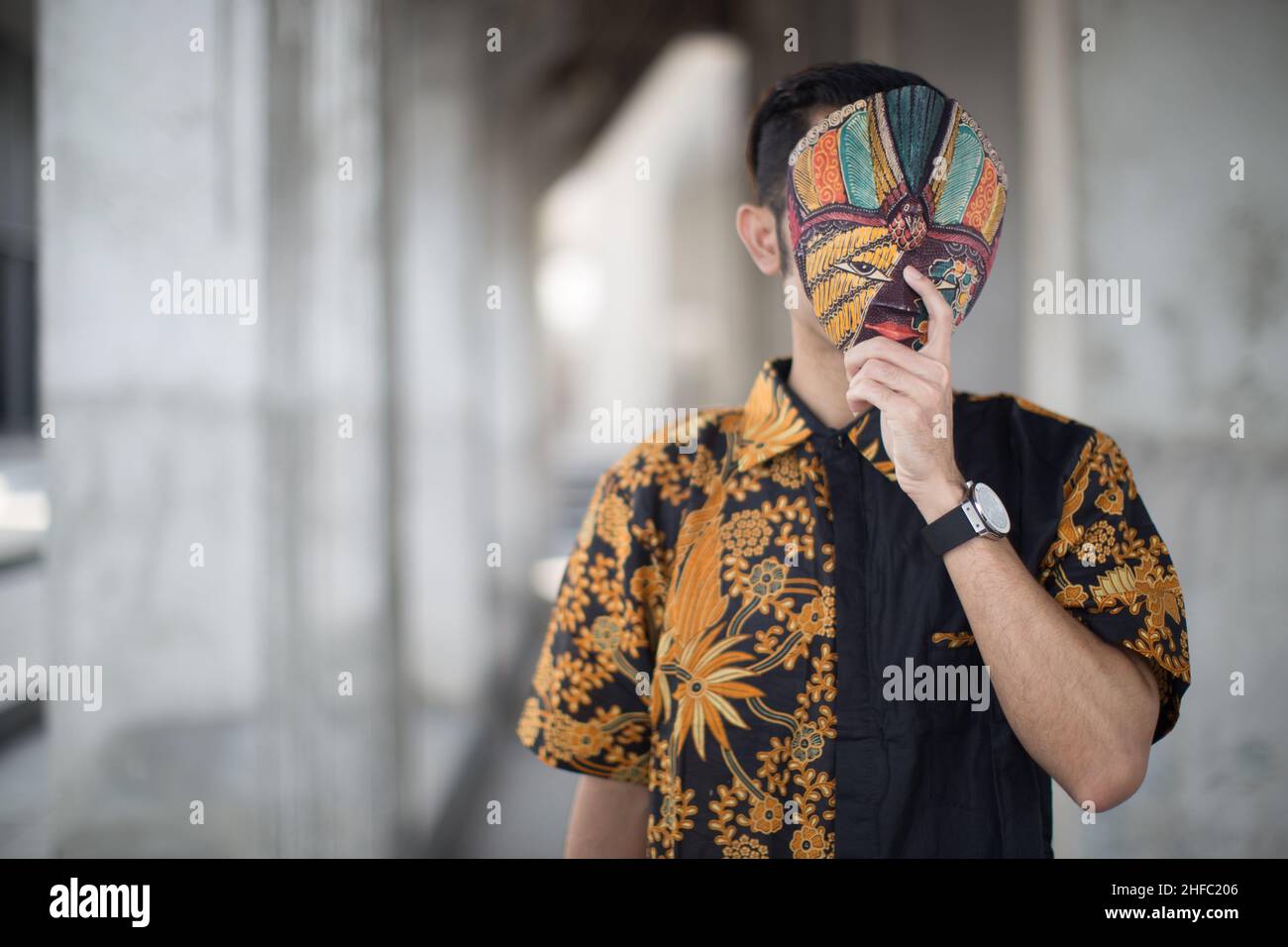 A young male model dressed in traditional Indonesian Batik and a Javanese mask at the Long Museum, West Bund, Shanghai, China Stock Photo