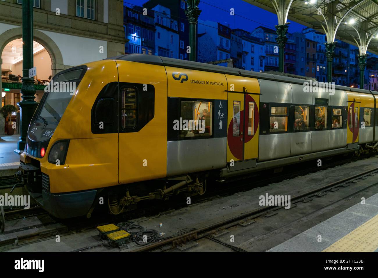 Porto, Portugal - 18 Nov 2020: Old vintage grey and yellow trains at terminus of Sao bento Train Station in Porto. Dirty grunge trains at station wait Stock Photo