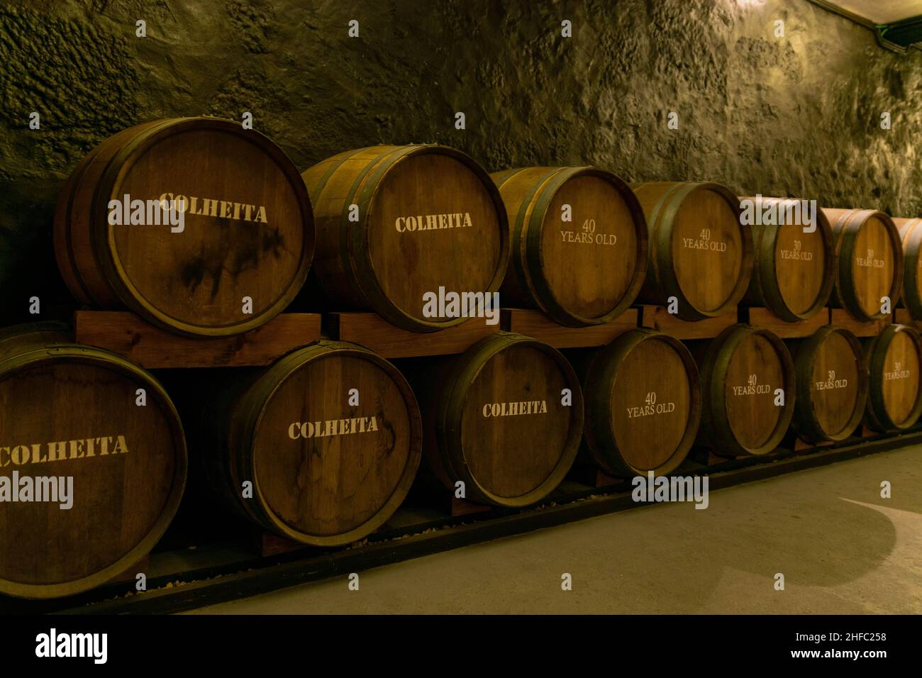 Wooden oak Port barrels in neat rows in Porto, Portugal. Winemaking concept background. Port, Fortified Wine and whisky are stored for years to mature Stock Photo