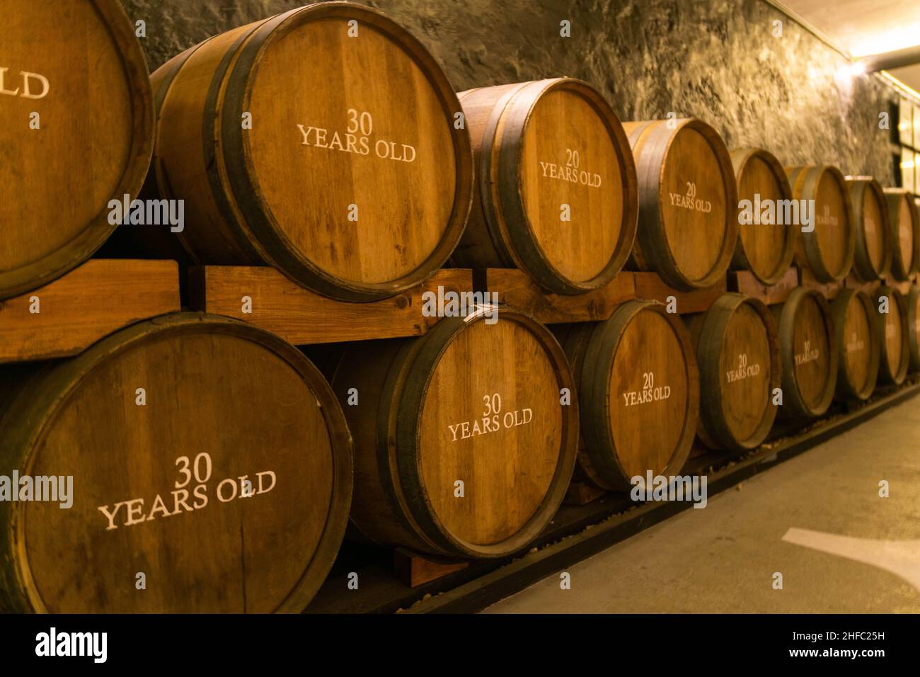 Wooden oak Port barrels in neat rows in Porto, Portugal. Winemaking concept background. Port, Fortified Wine and whisky are stored for years to mature Stock Photo