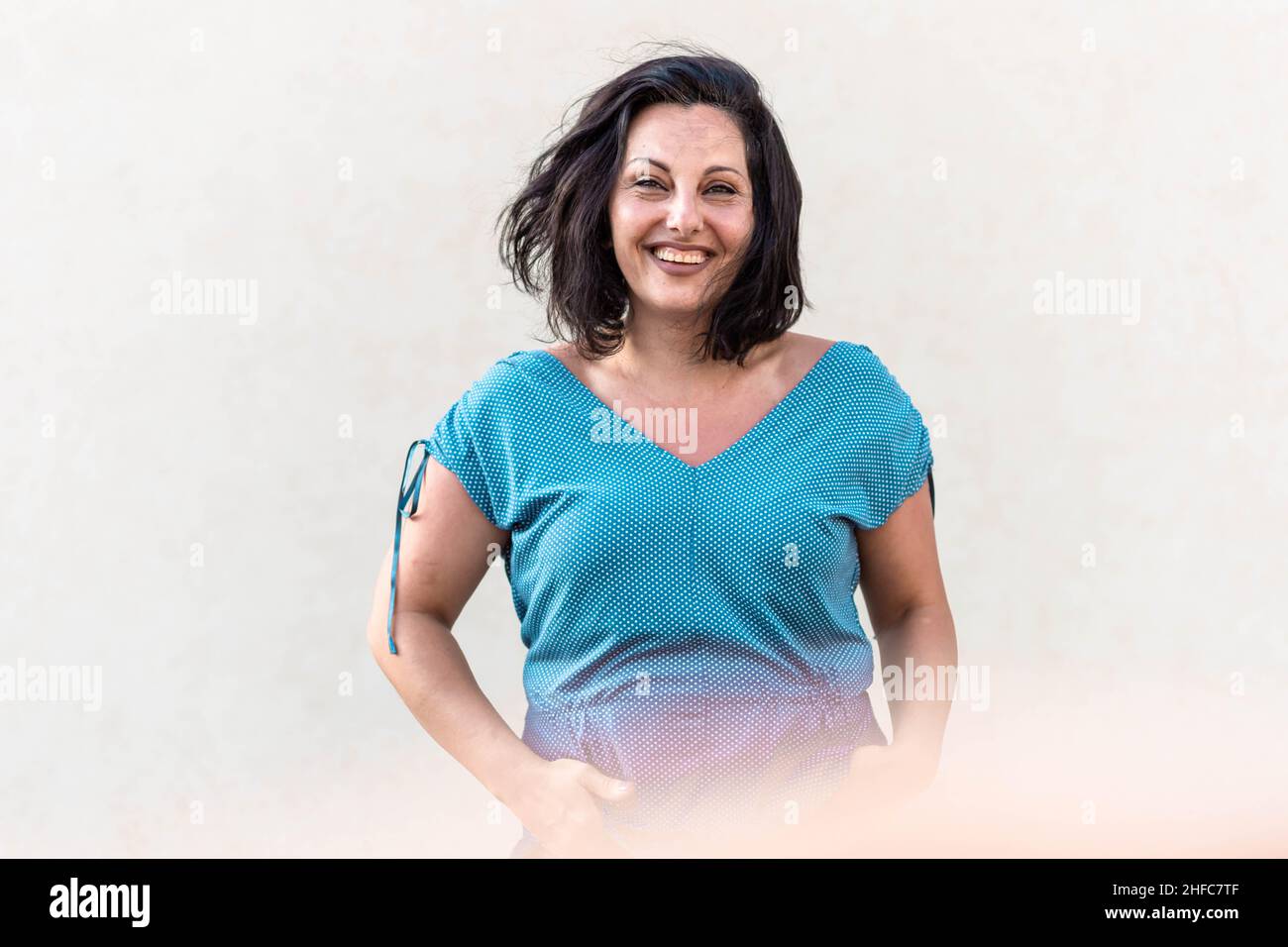 Middle age confident, brunette woman standing and smiling Stock Photo