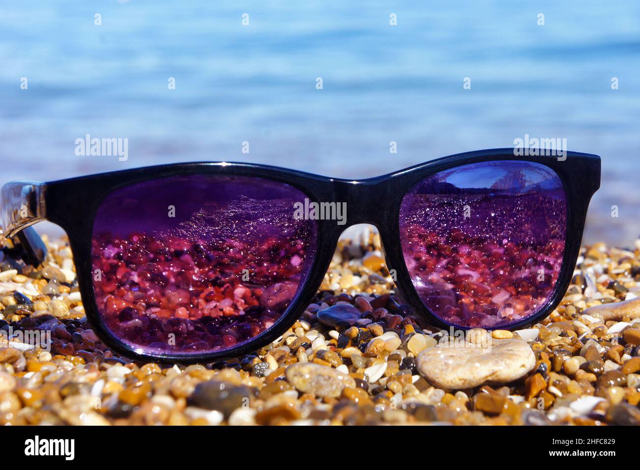 sunglasses on the beach, on stones, close-up Stock Photo