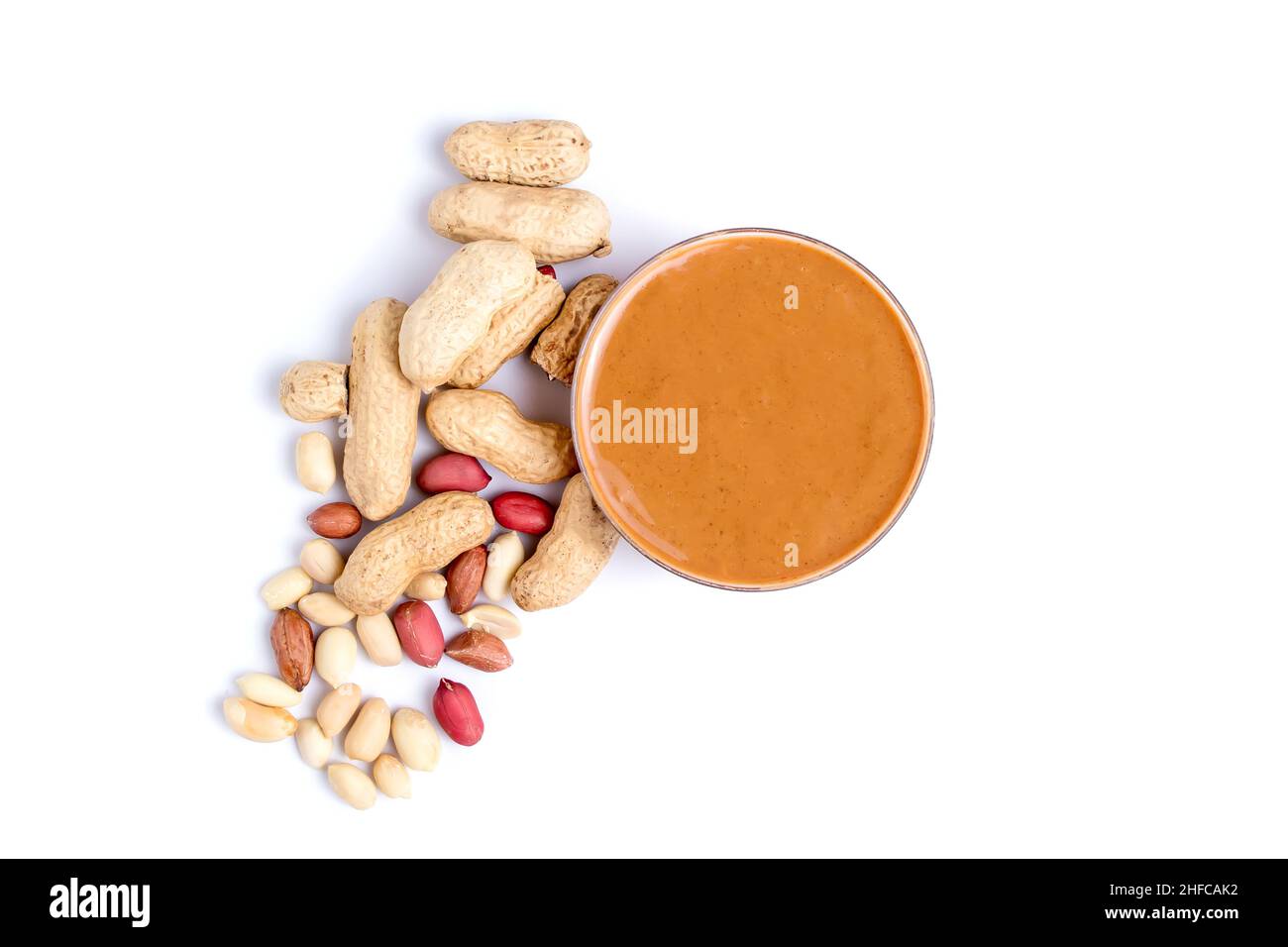 Peanut butter isolated and peanuts in the peel scattered on the white