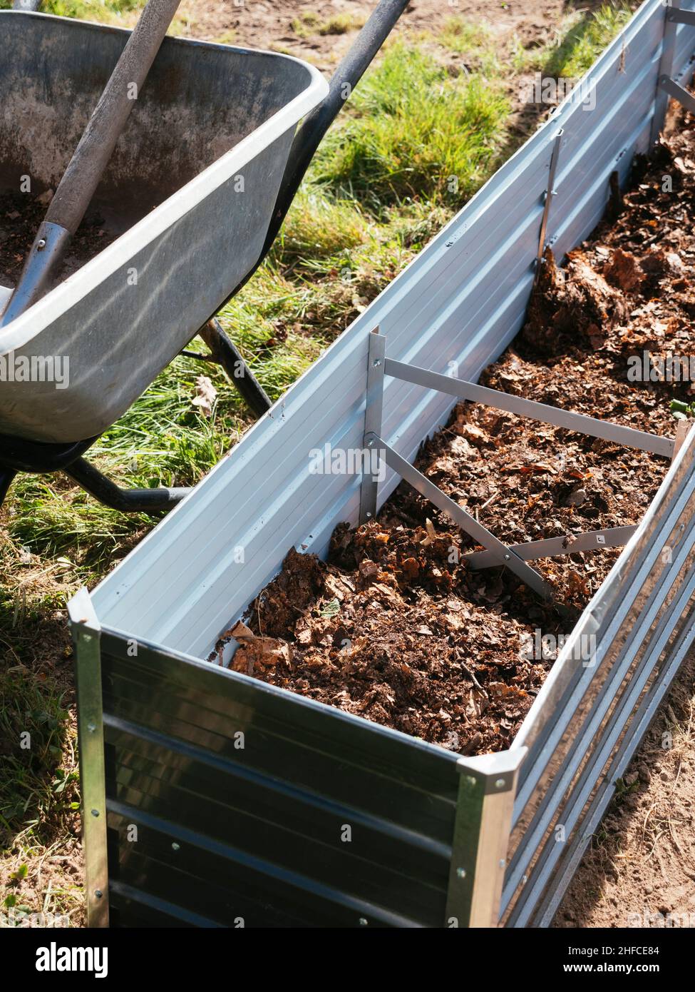 New raised bed being filled with compost and leaf mold. Stock Photo