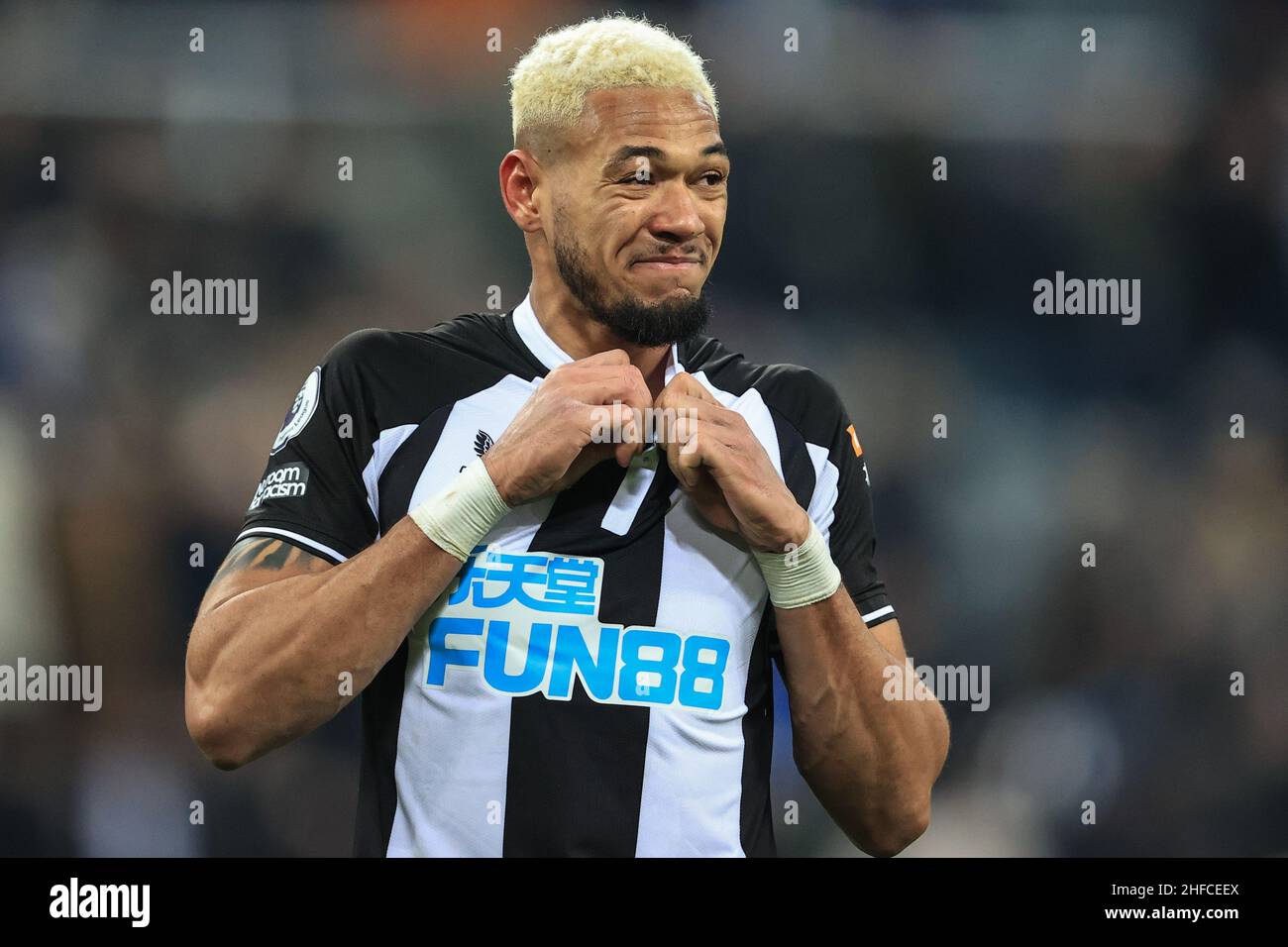 Joelinton #7 of Newcastle United unfastens his shirt as he